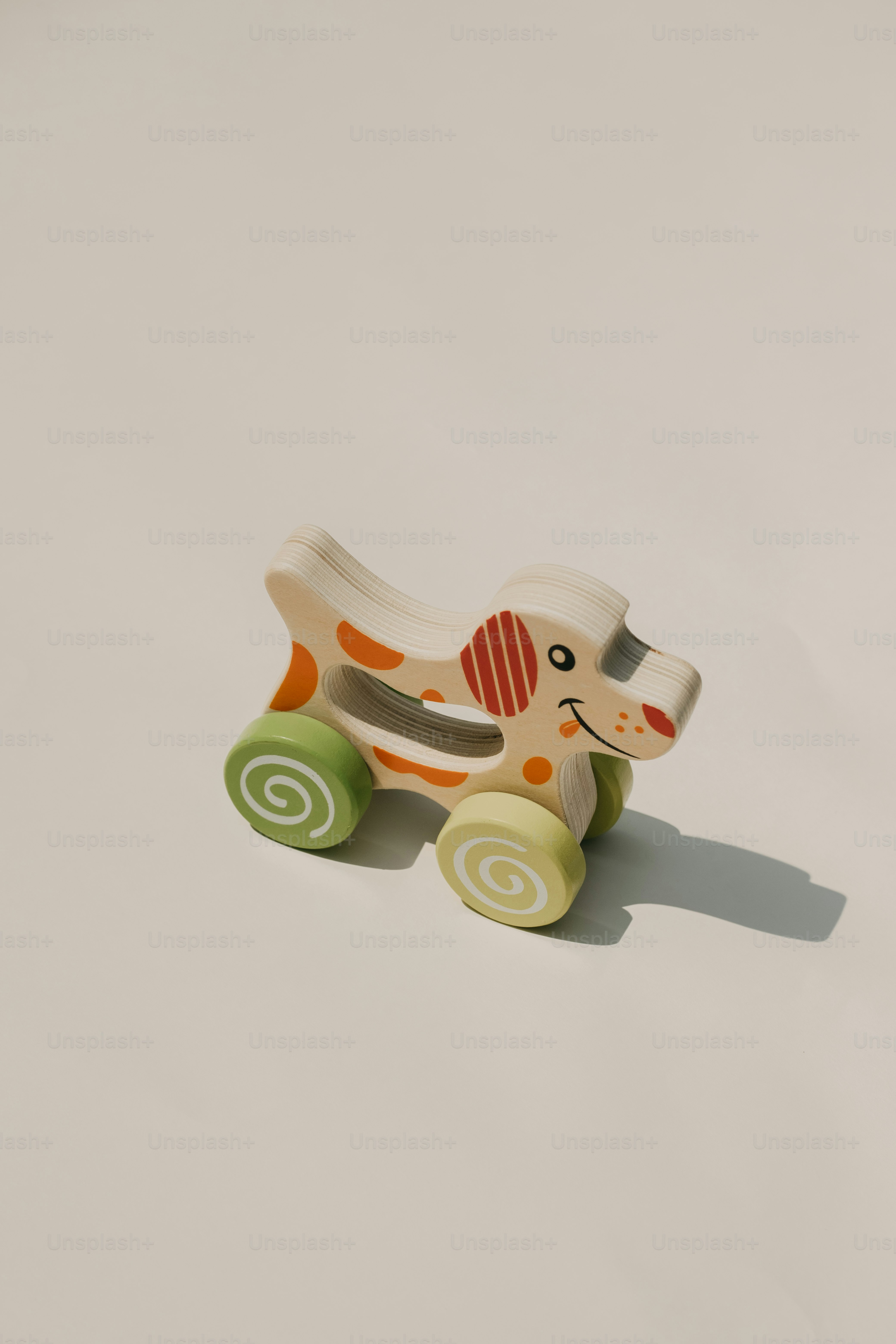 Wooden dog toy with wheels on a white background