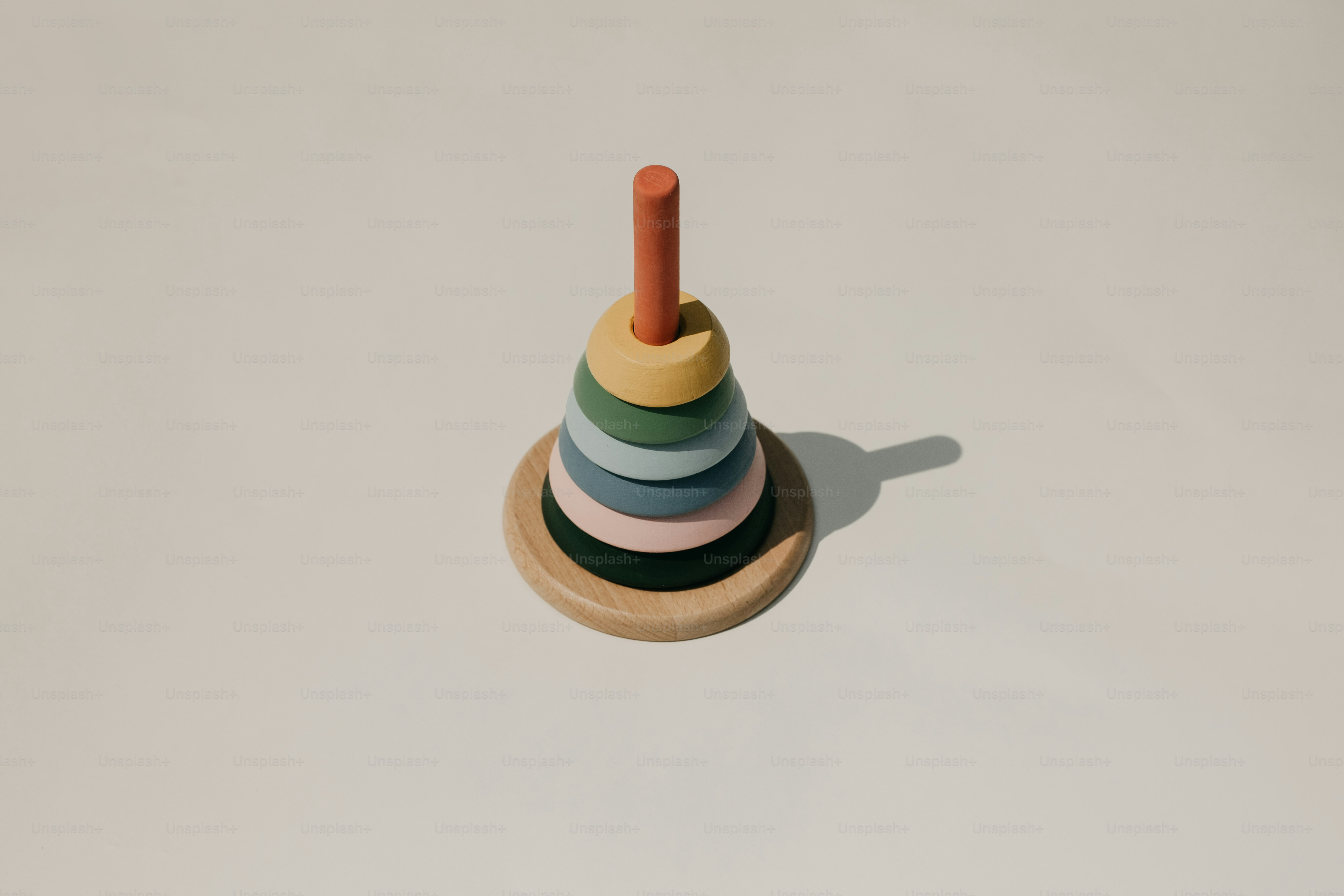 Wooden stacking toy with pastel colored rings photo – Toy Image on Unsplash