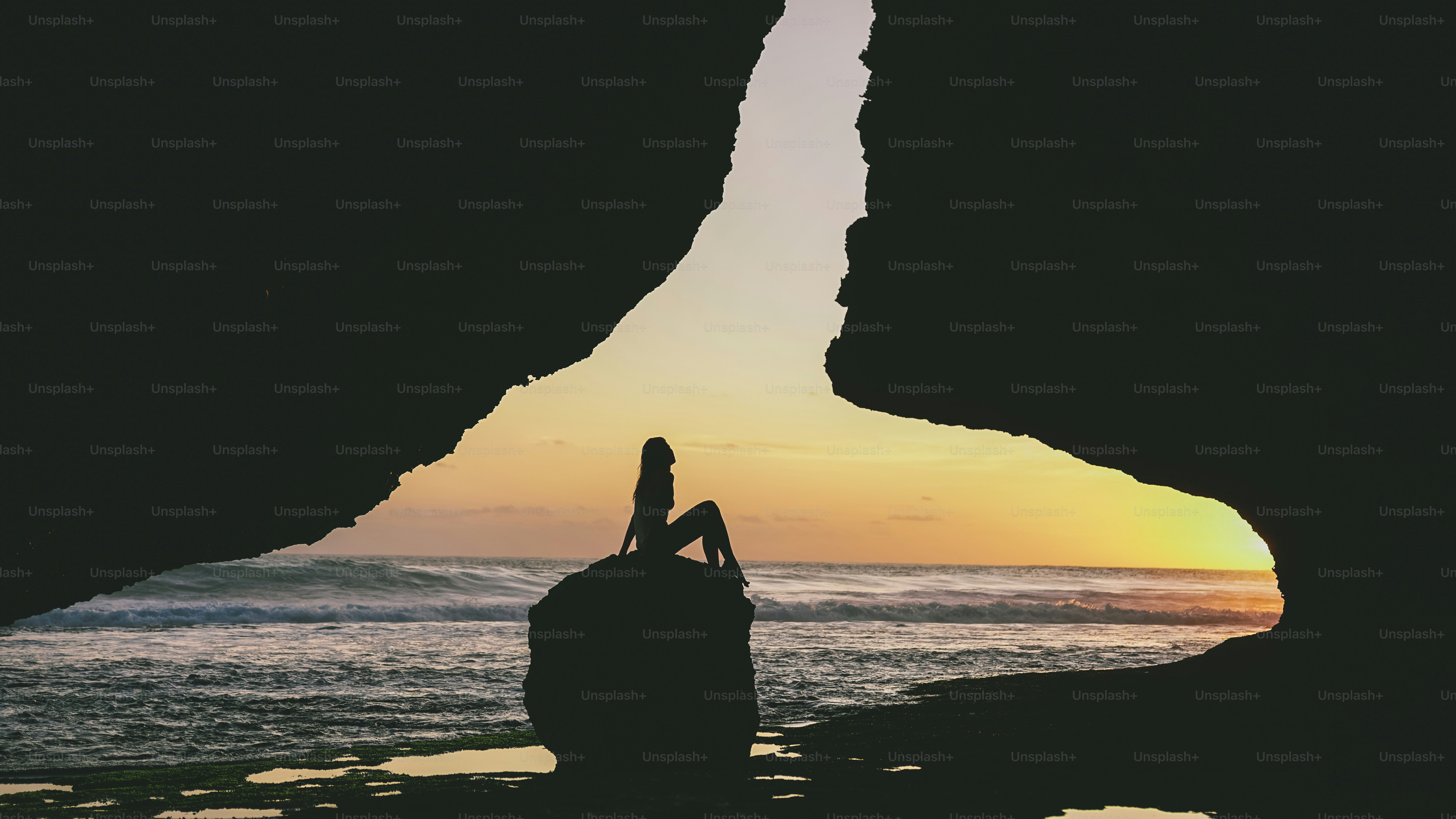 Silhouette of a woman on rock at sunset