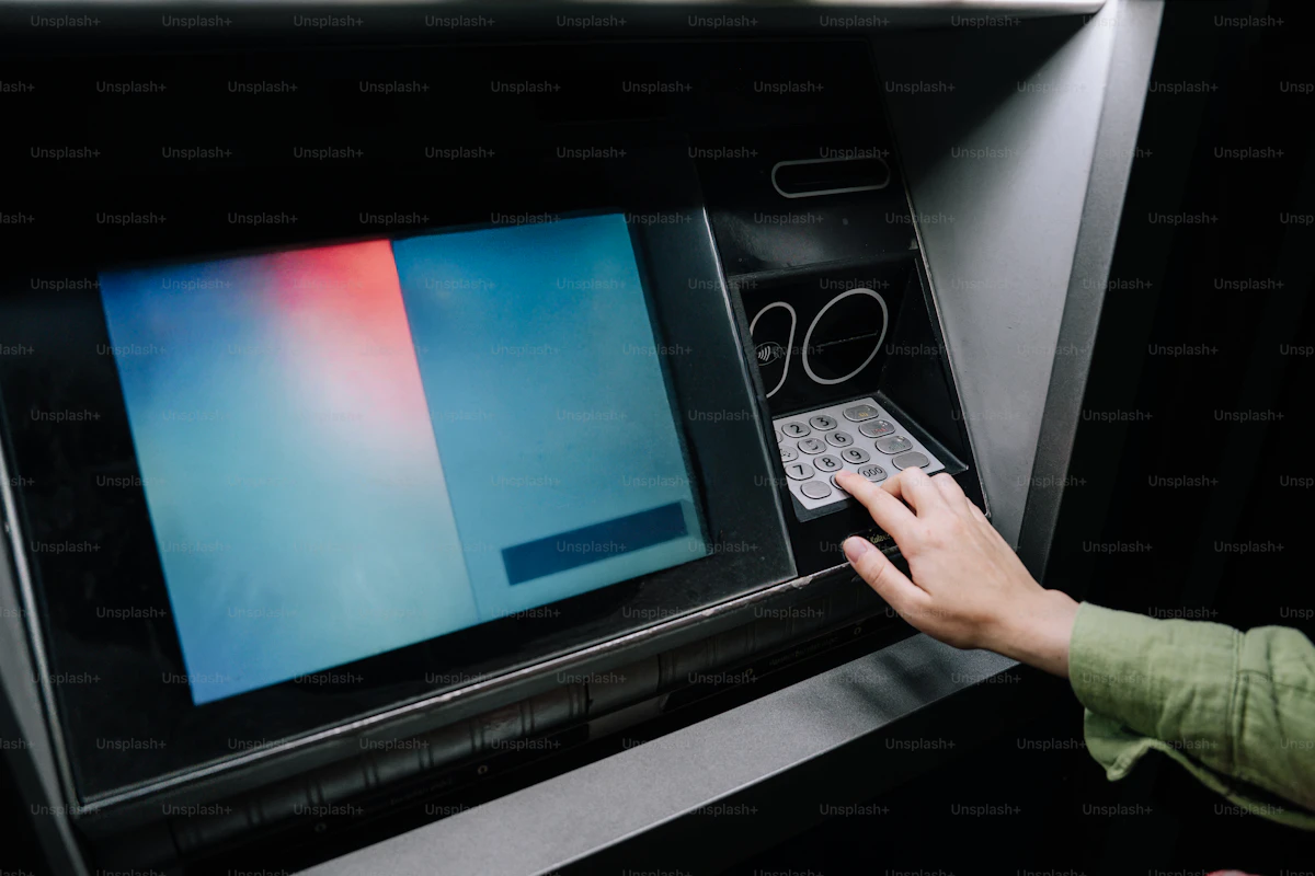 Eine Person bedient einen Geldautomaten