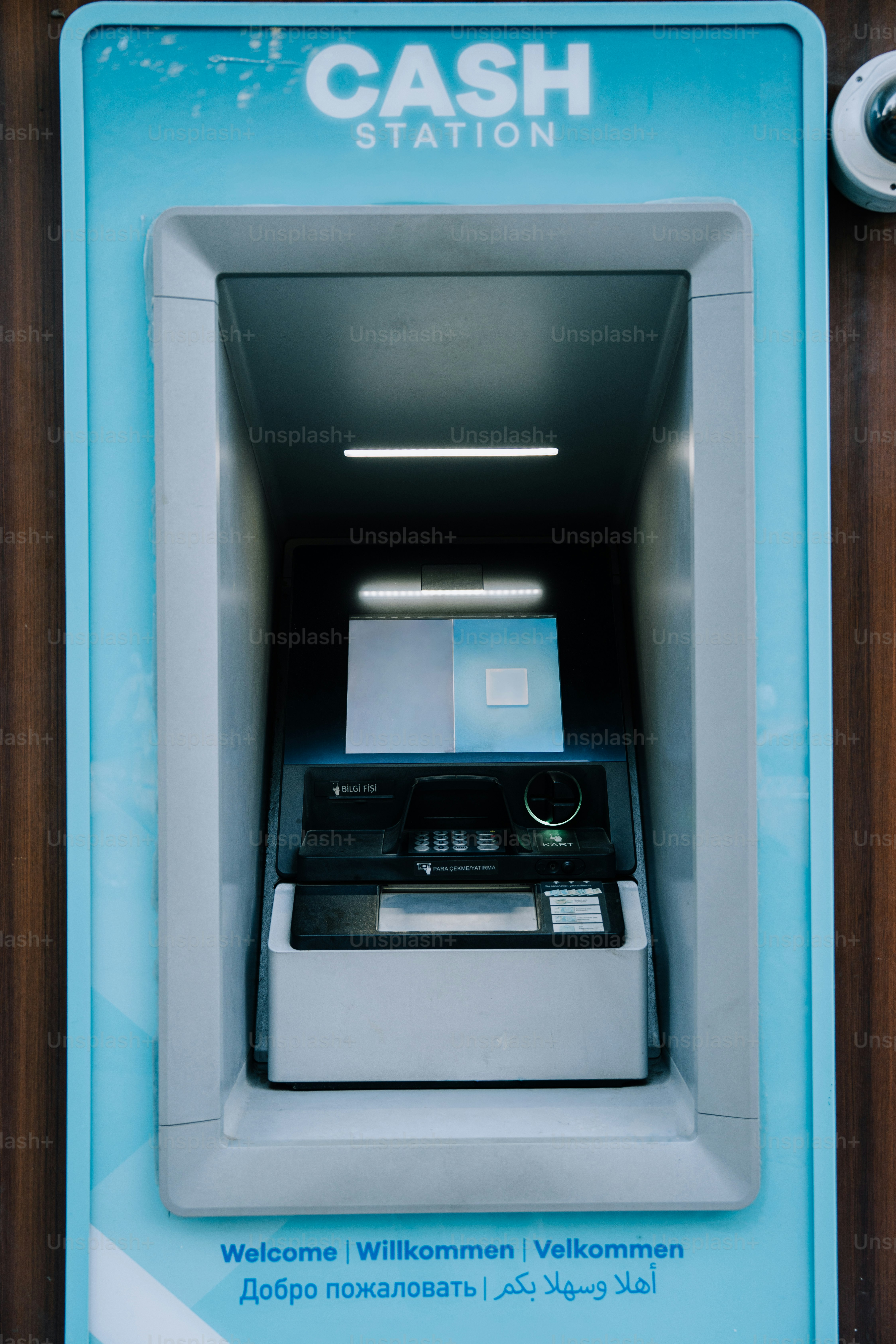 Cash station atm with multilingual welcome message.