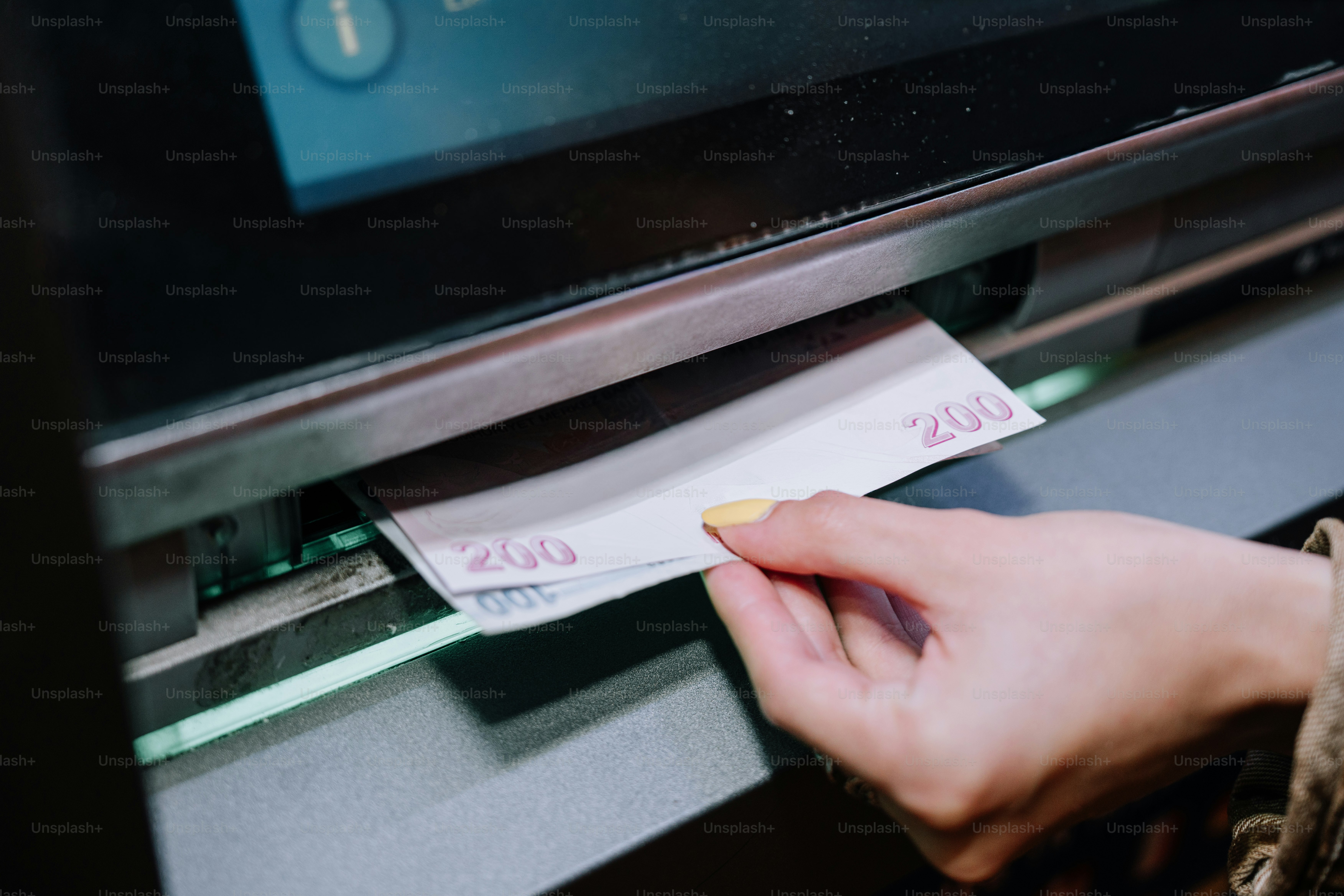Hand inserting banknotes into an atm machine. photo – Money Image on ...