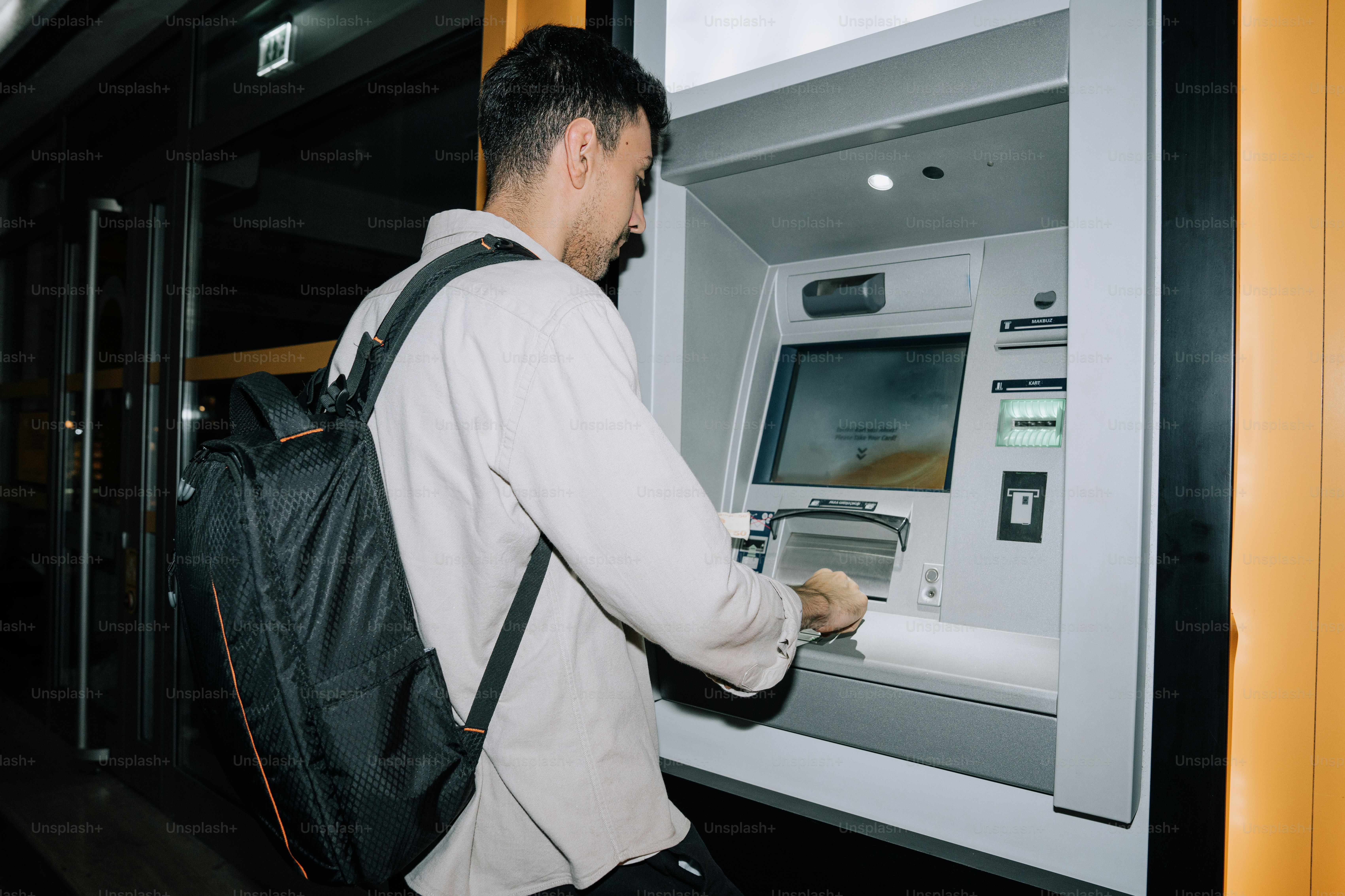 Homme utilisant un distributeur automatique de billets la nuit photo –  Image de Argent sur Unsplash