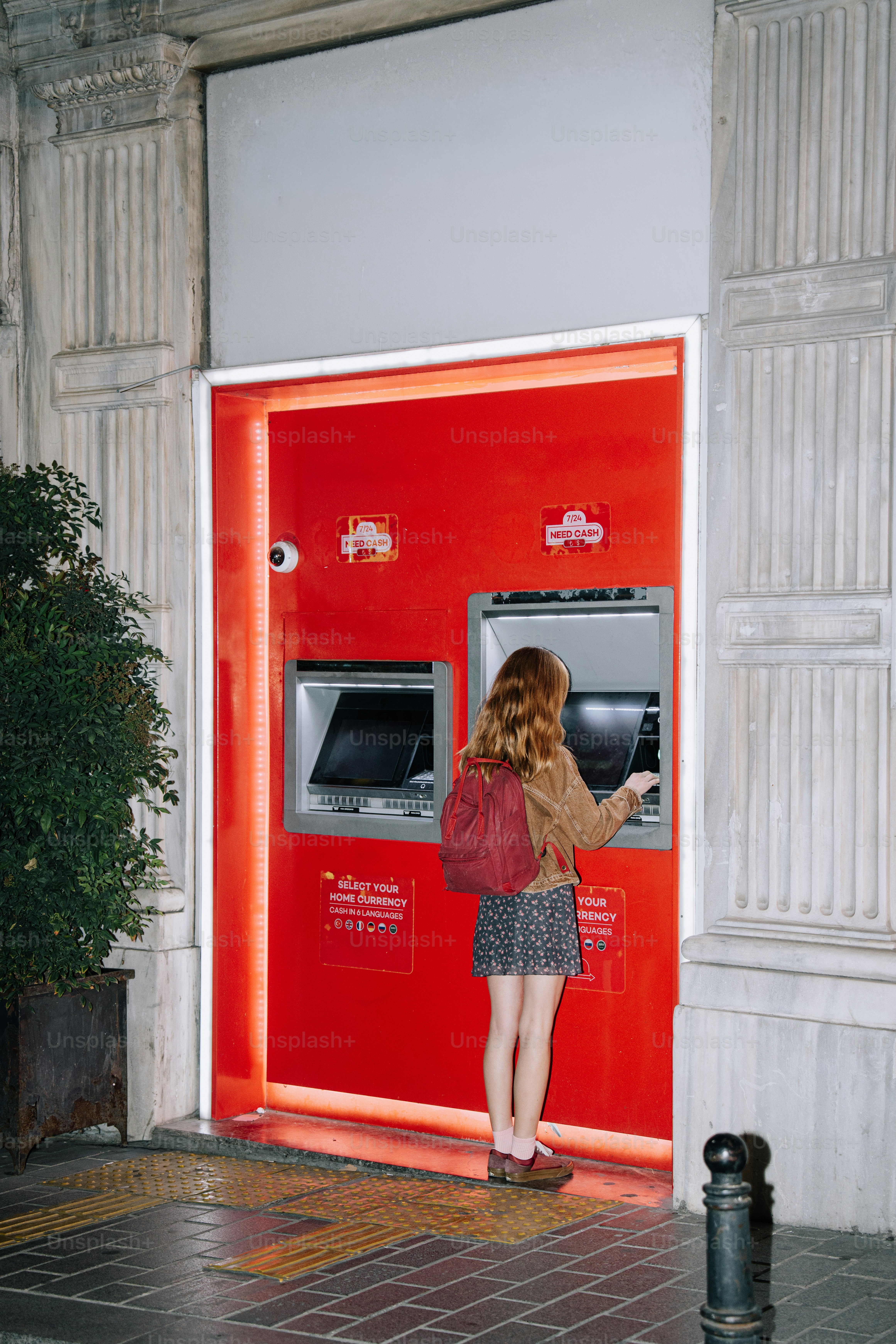 Donna che usa un bancomat di notte