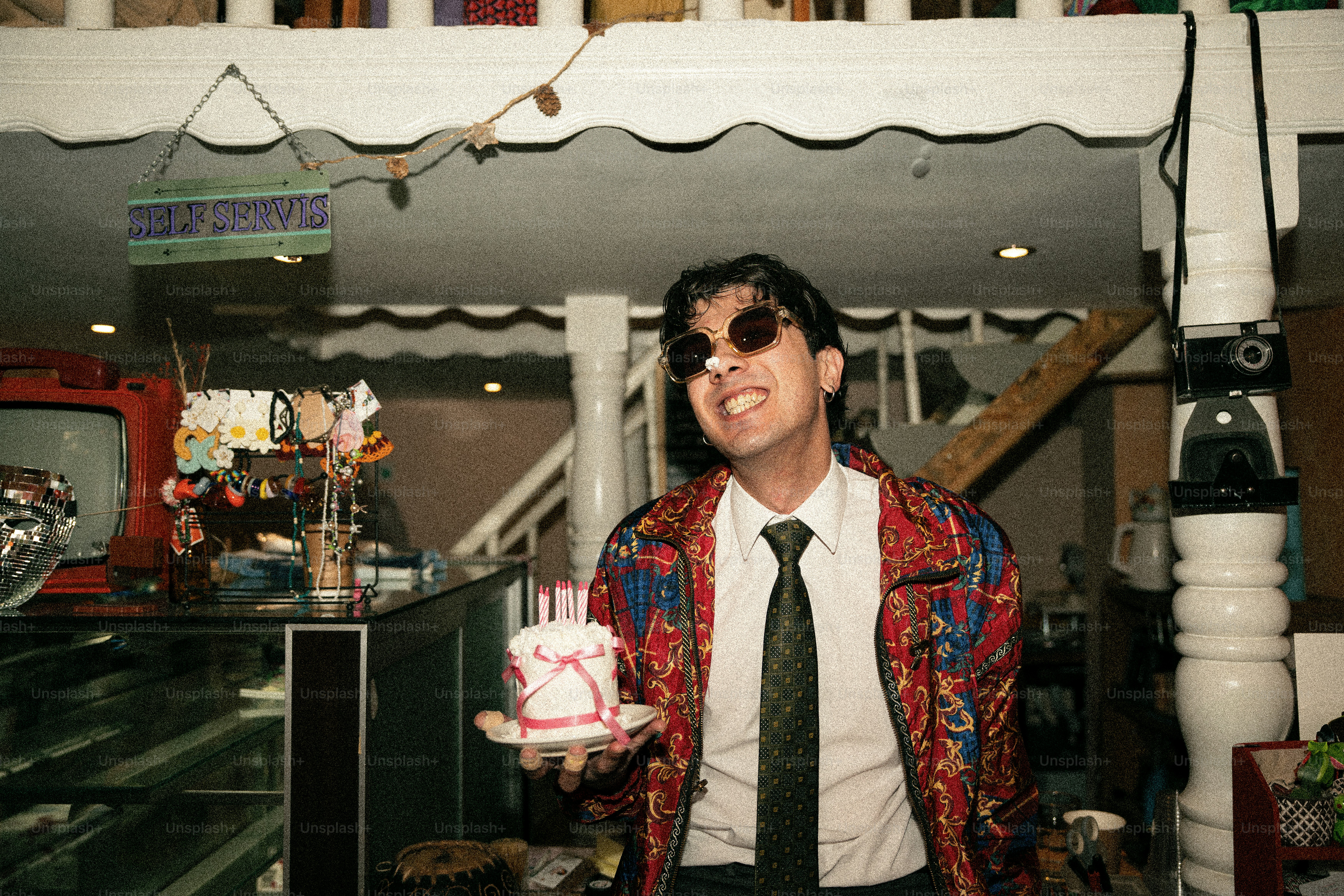 Man in sunglasses holding a small birthday cake