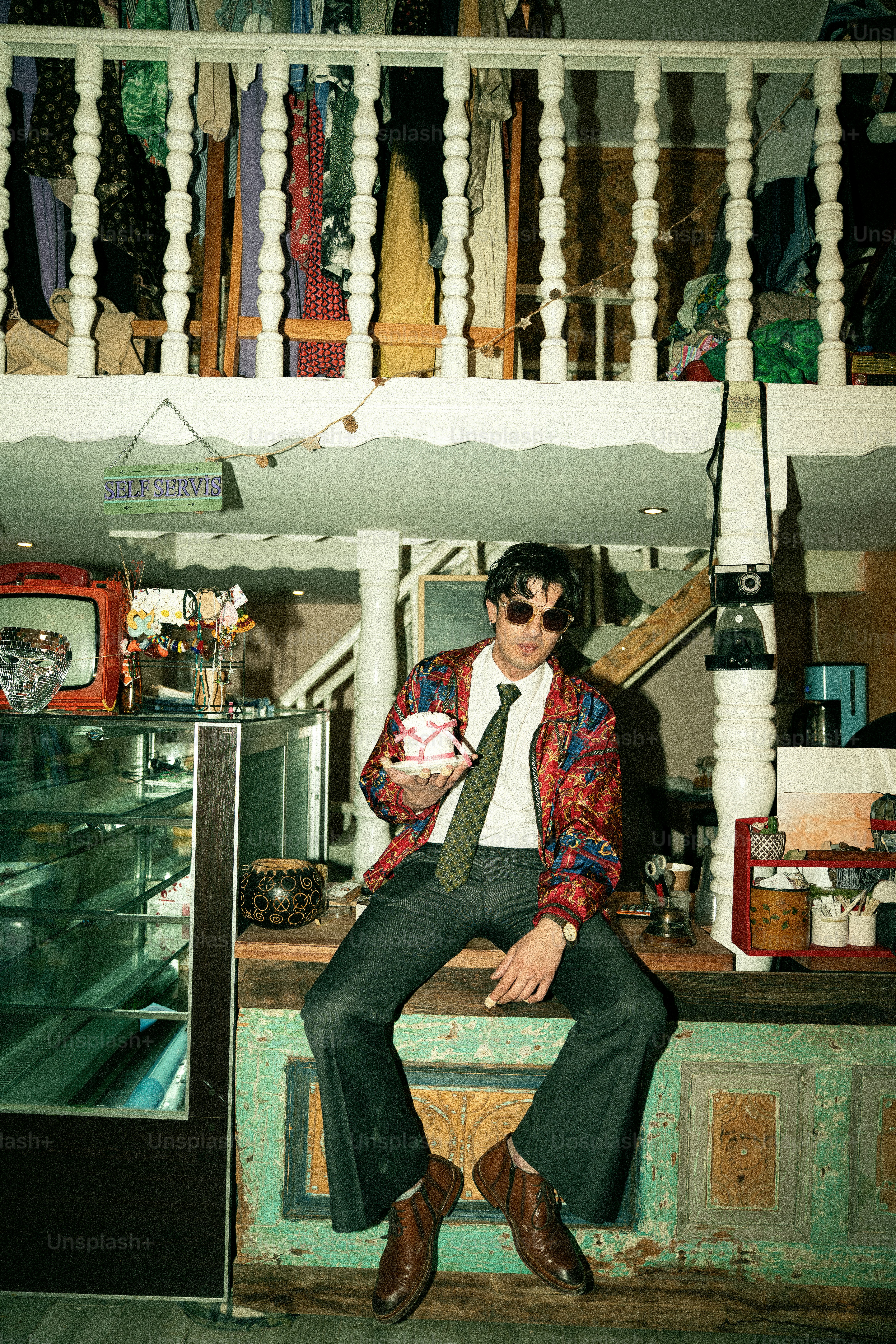 Man in stylish outfit holding coffee cup in cafe