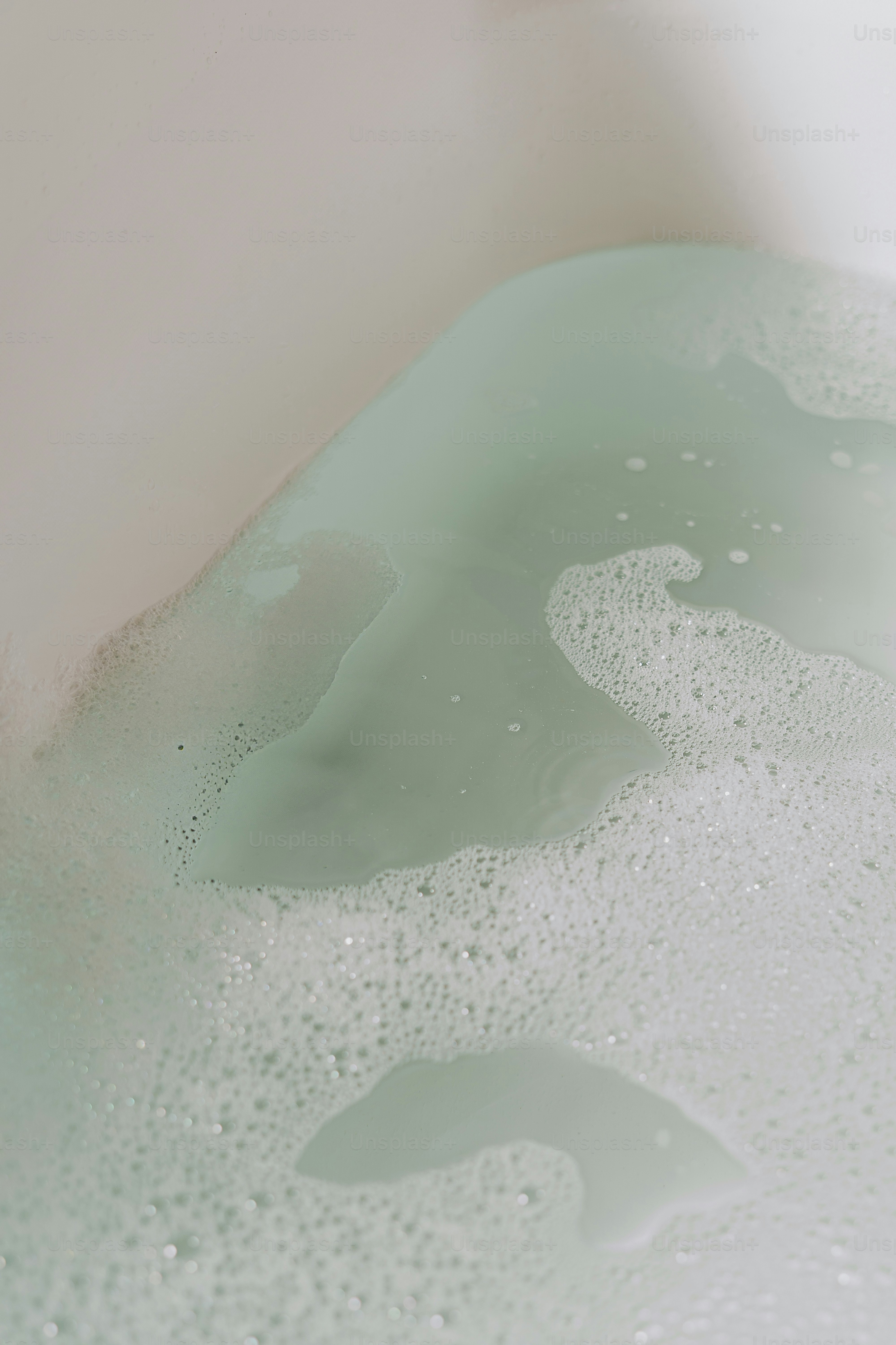 Bubbles and teal water in a bathtub