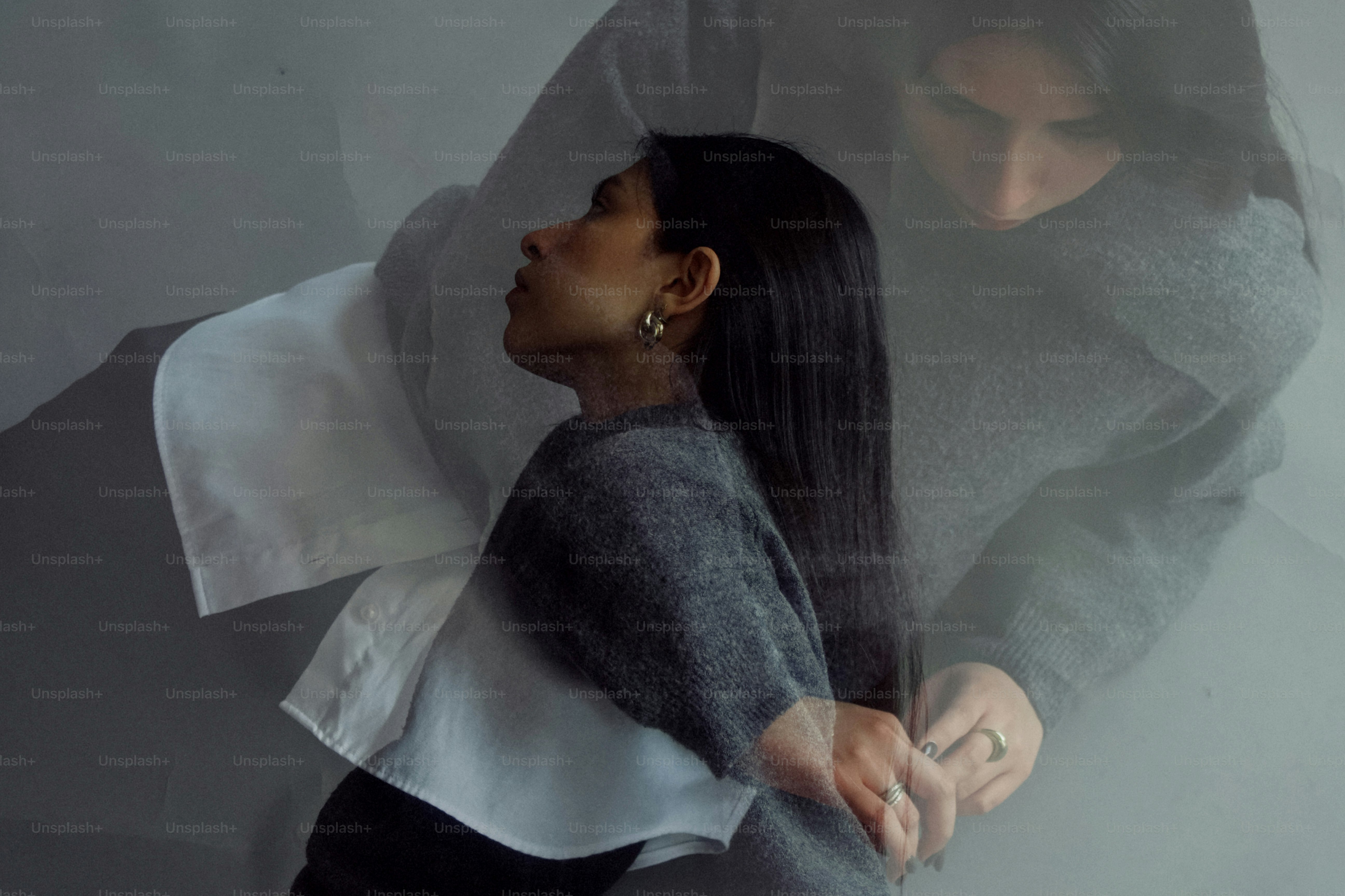 Mulher de camisola cinza com os braços cruzados