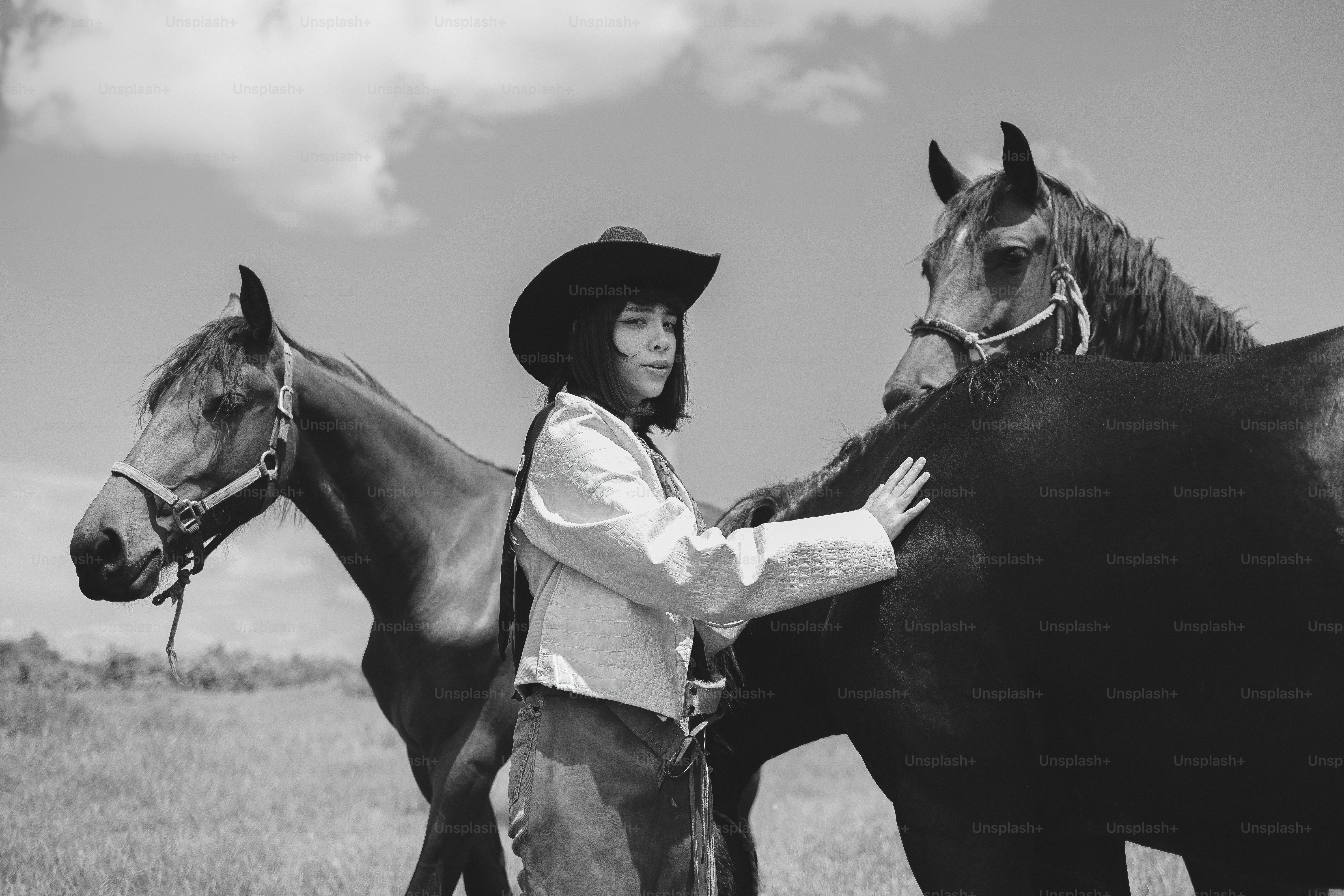 Femme en chapeau de cow-boy avec deux chevaux