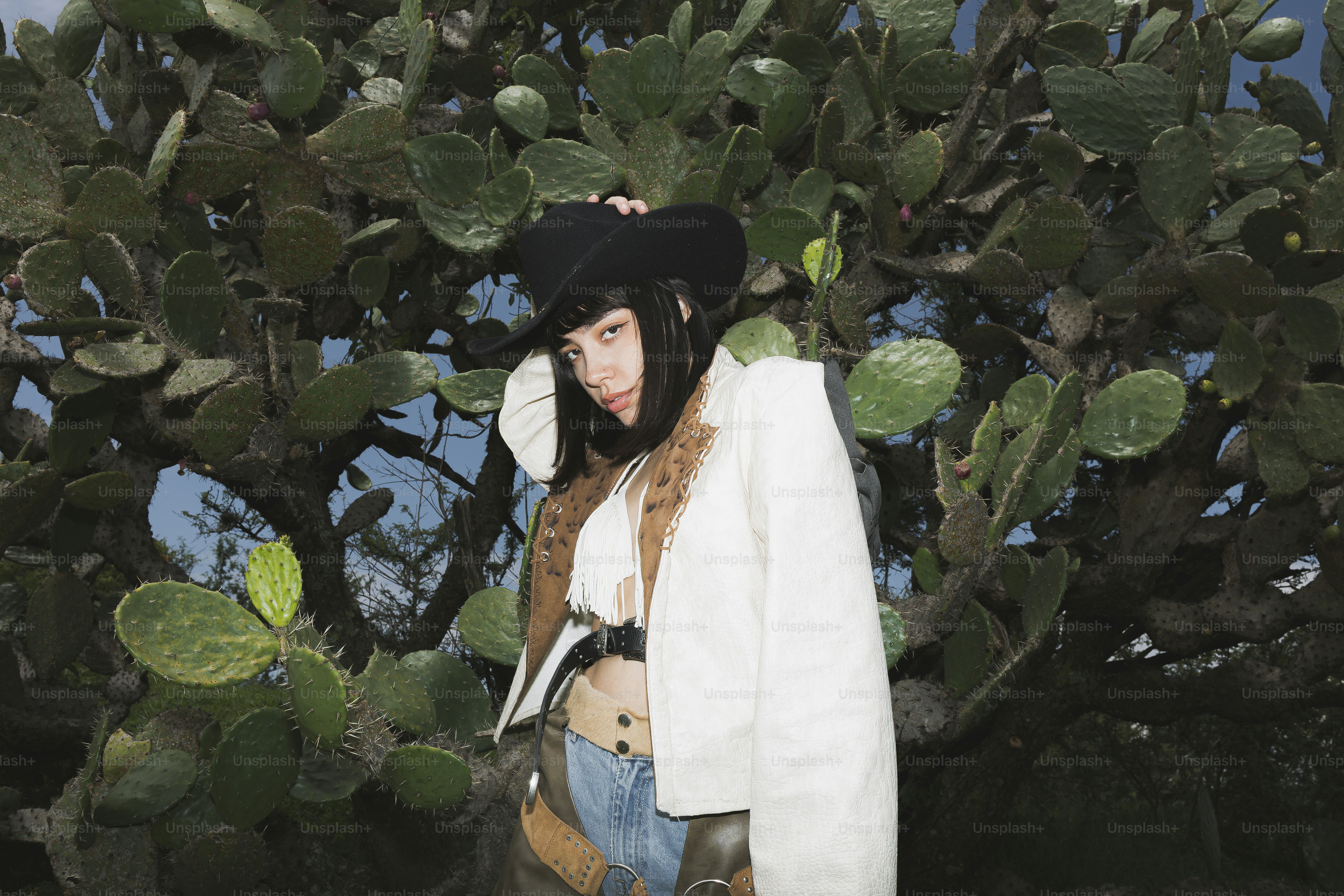 Femme en chapeau de cow-boy et veste près des cactus