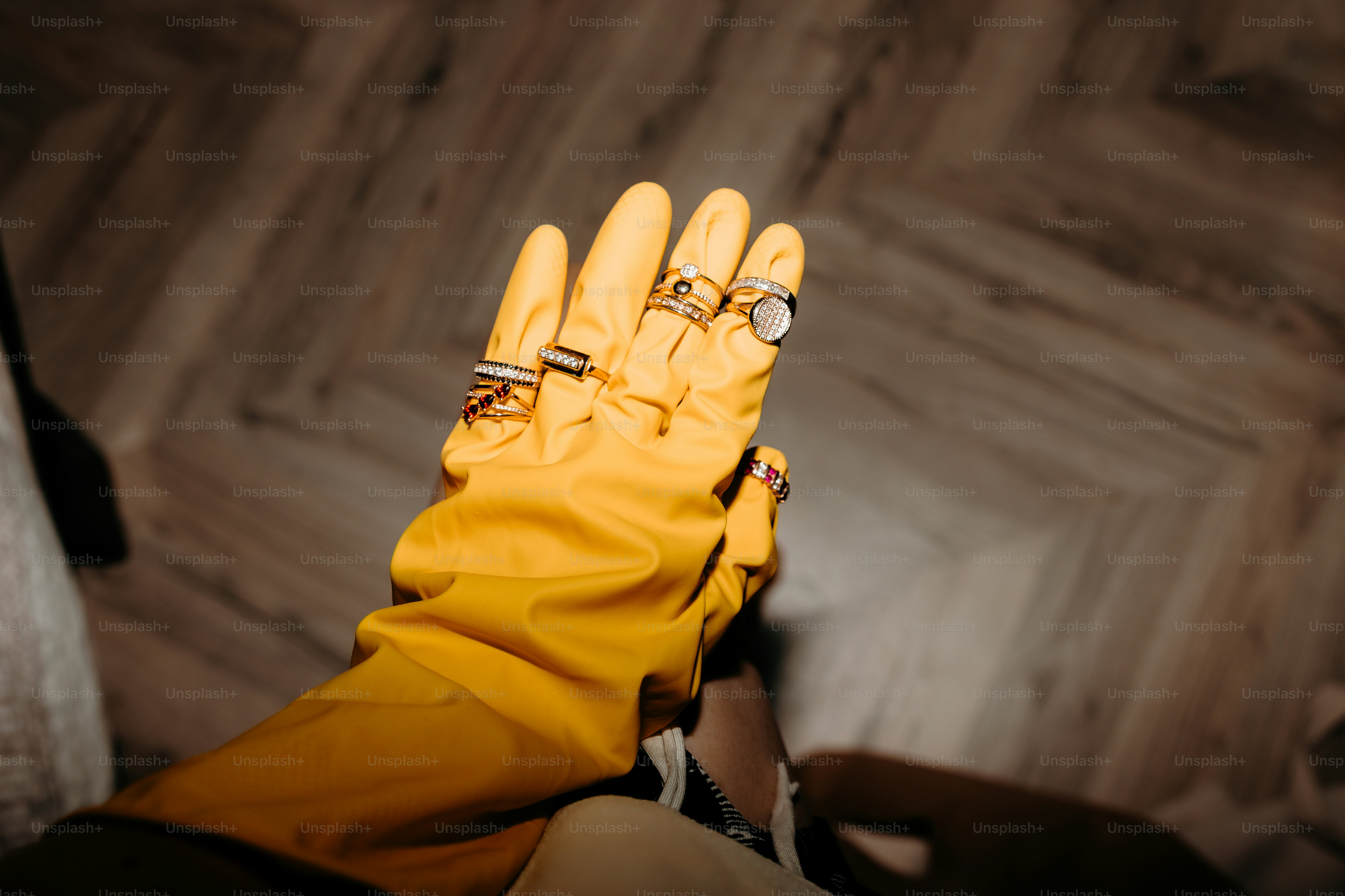 Yellow glove with multiple rings on fingers