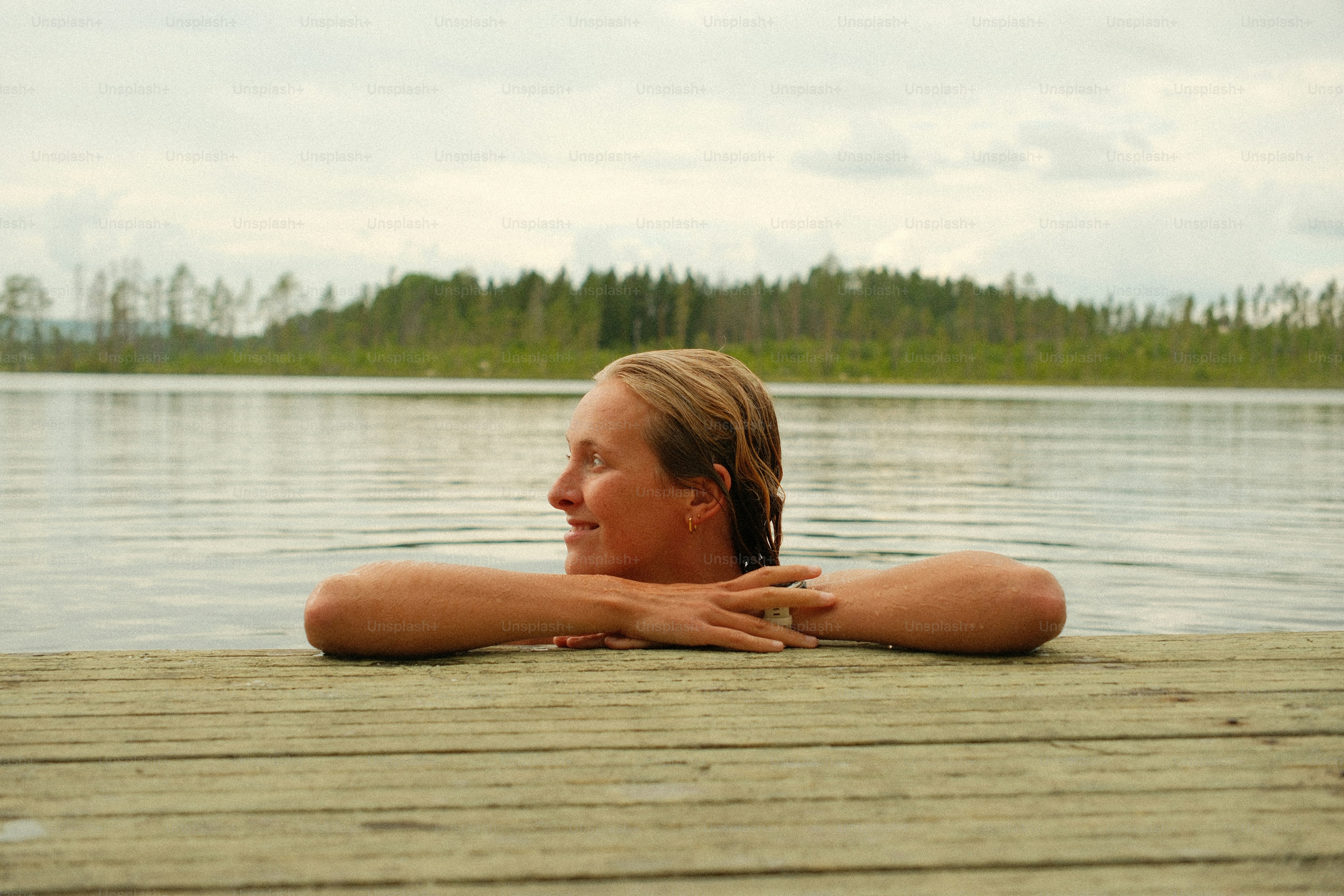 Woman resting on wooden dock in lake