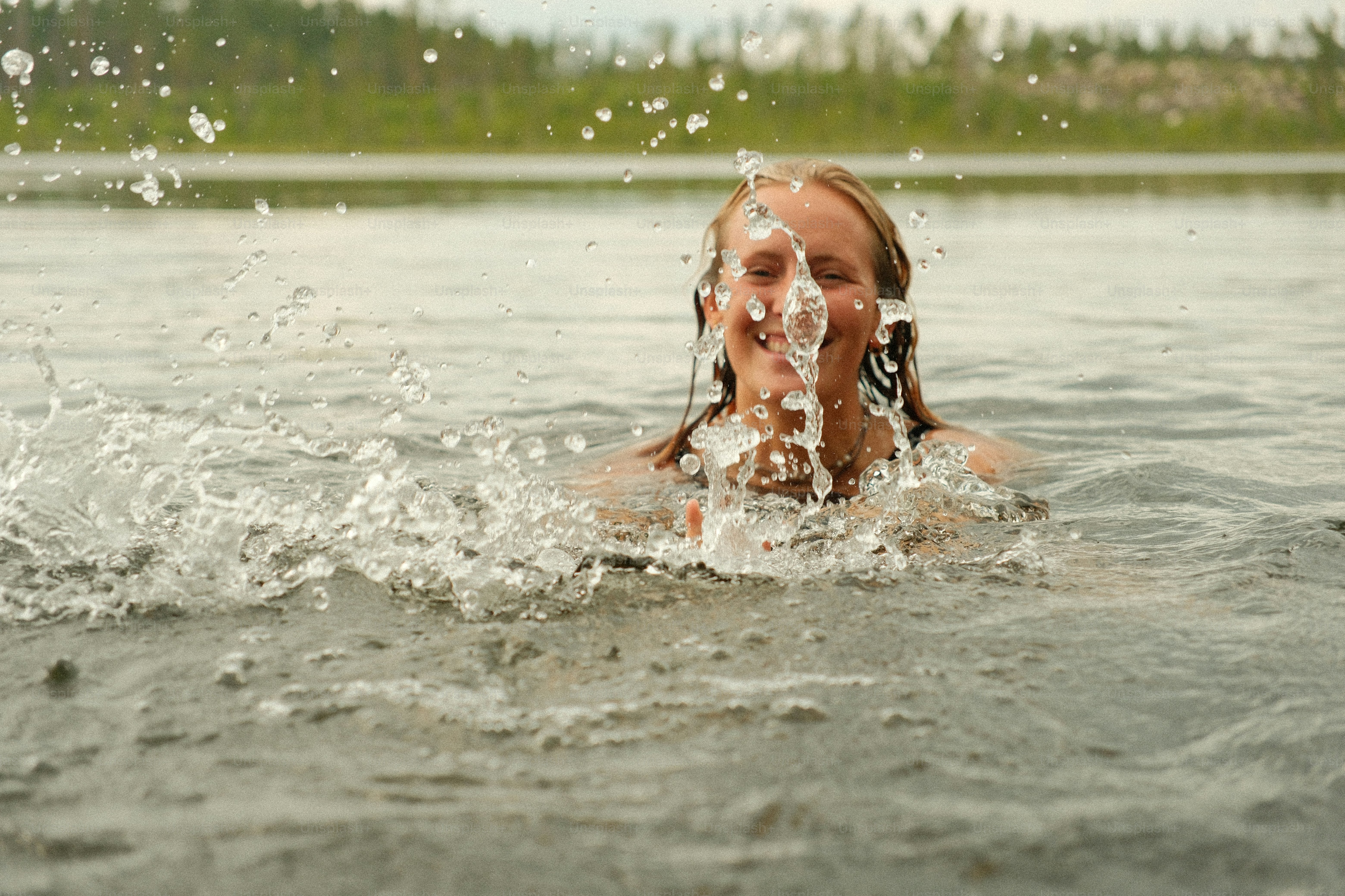 Woman splashing water while swimming in a lake