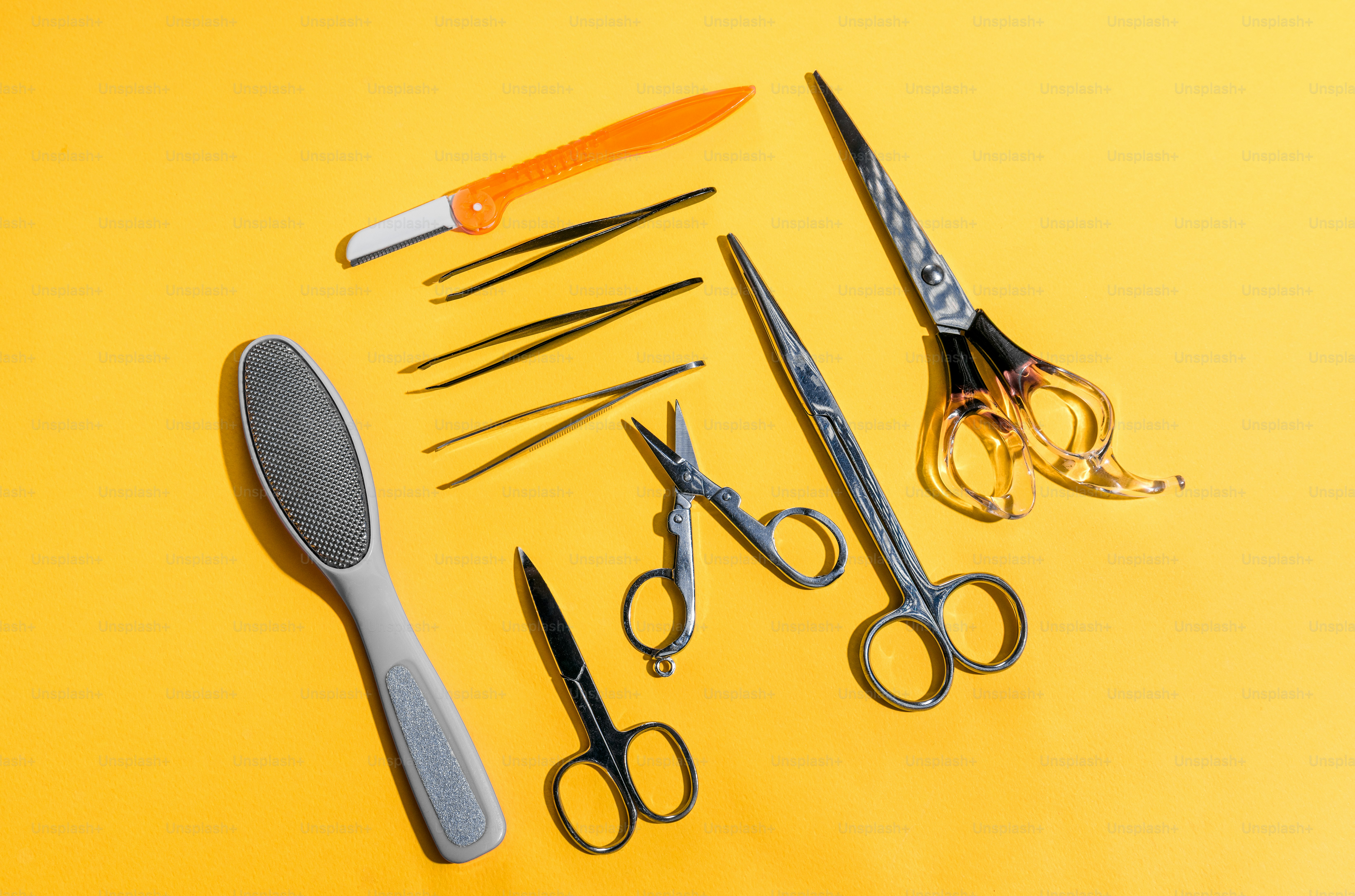 Various grooming and manicure tools arranged on yellow background