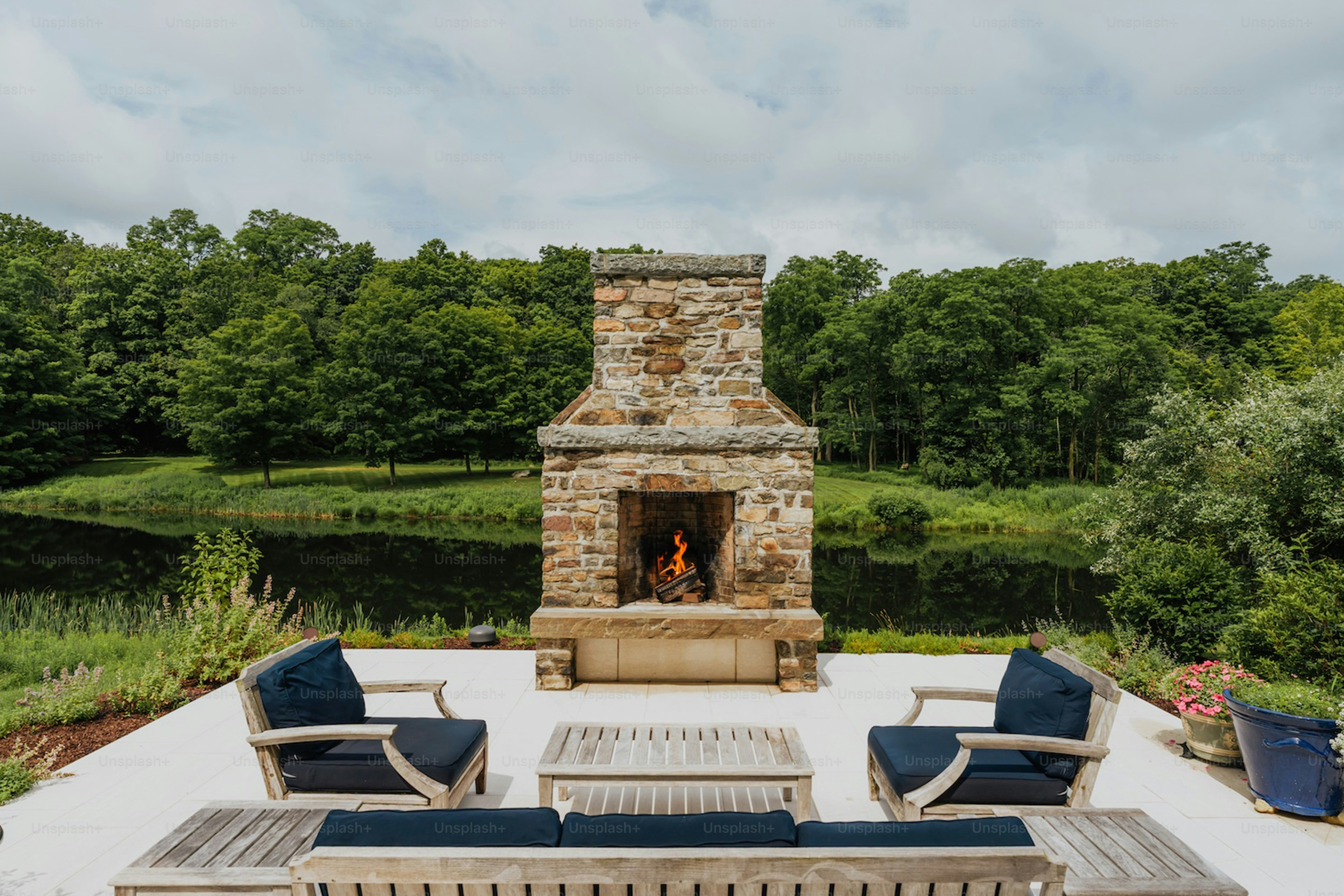 Stone fireplace with seating area by a lake