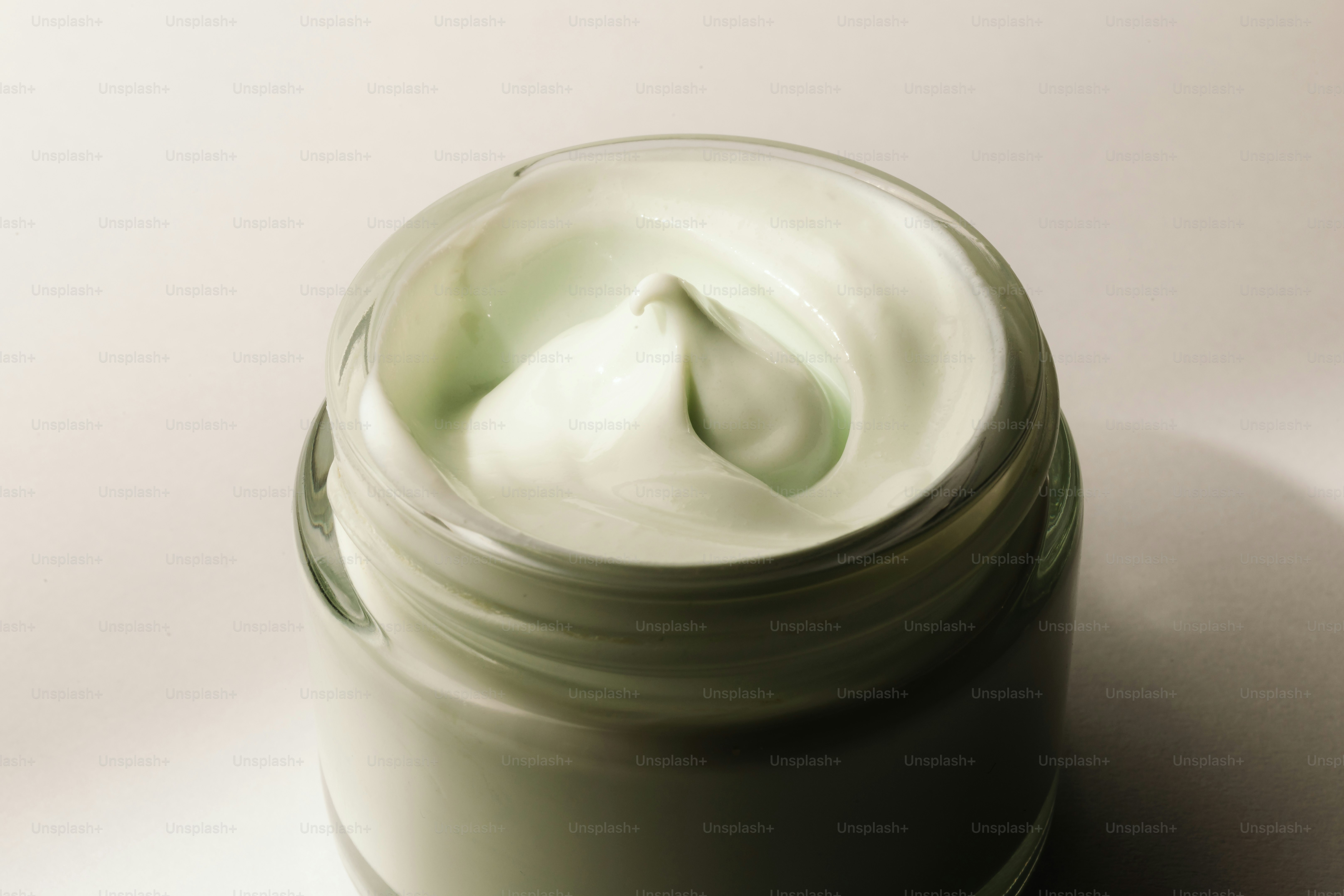 Primer plano de crema verde en un frasco de vidrio