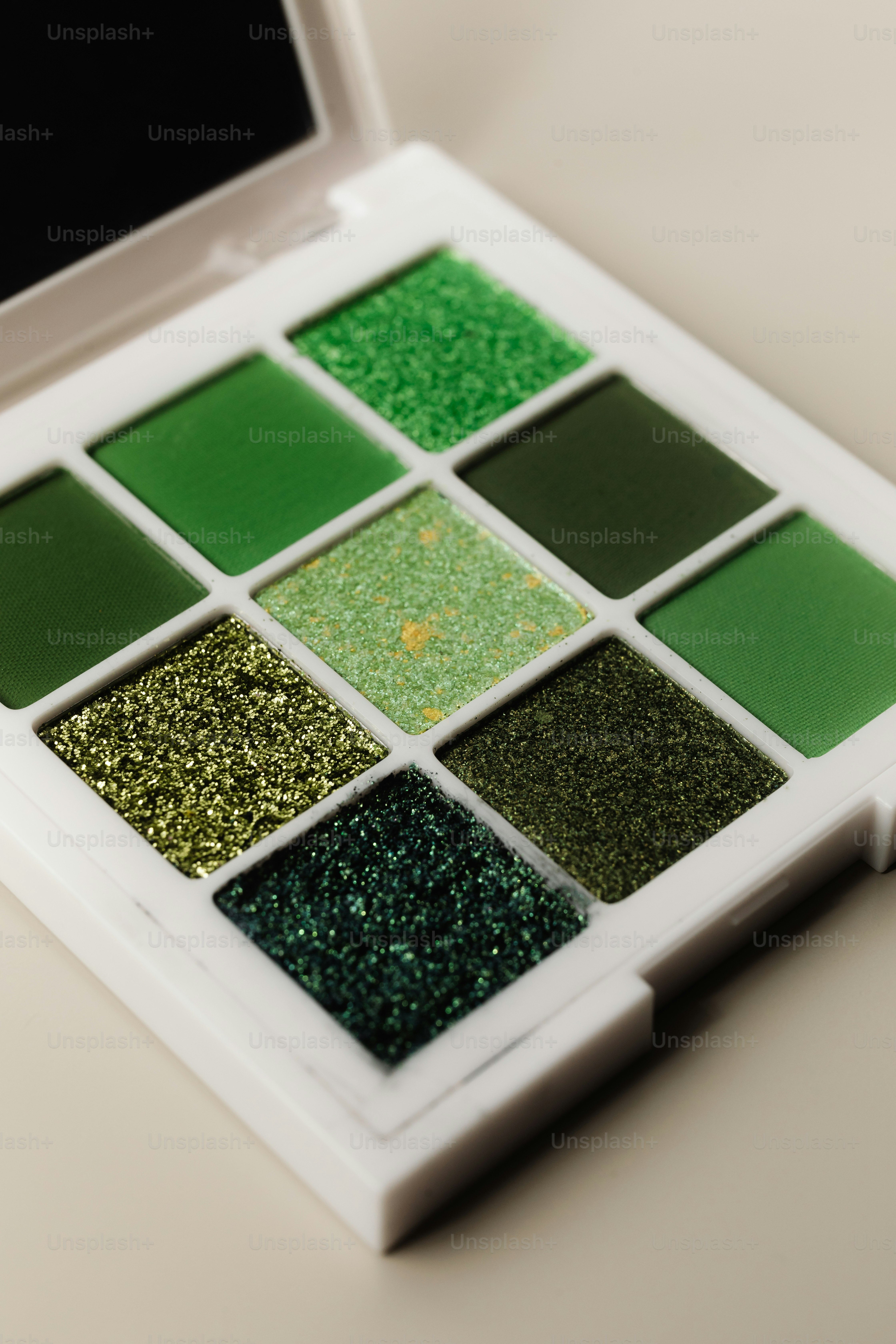 Nueve tonos de sombra de ojos verde en una paleta.