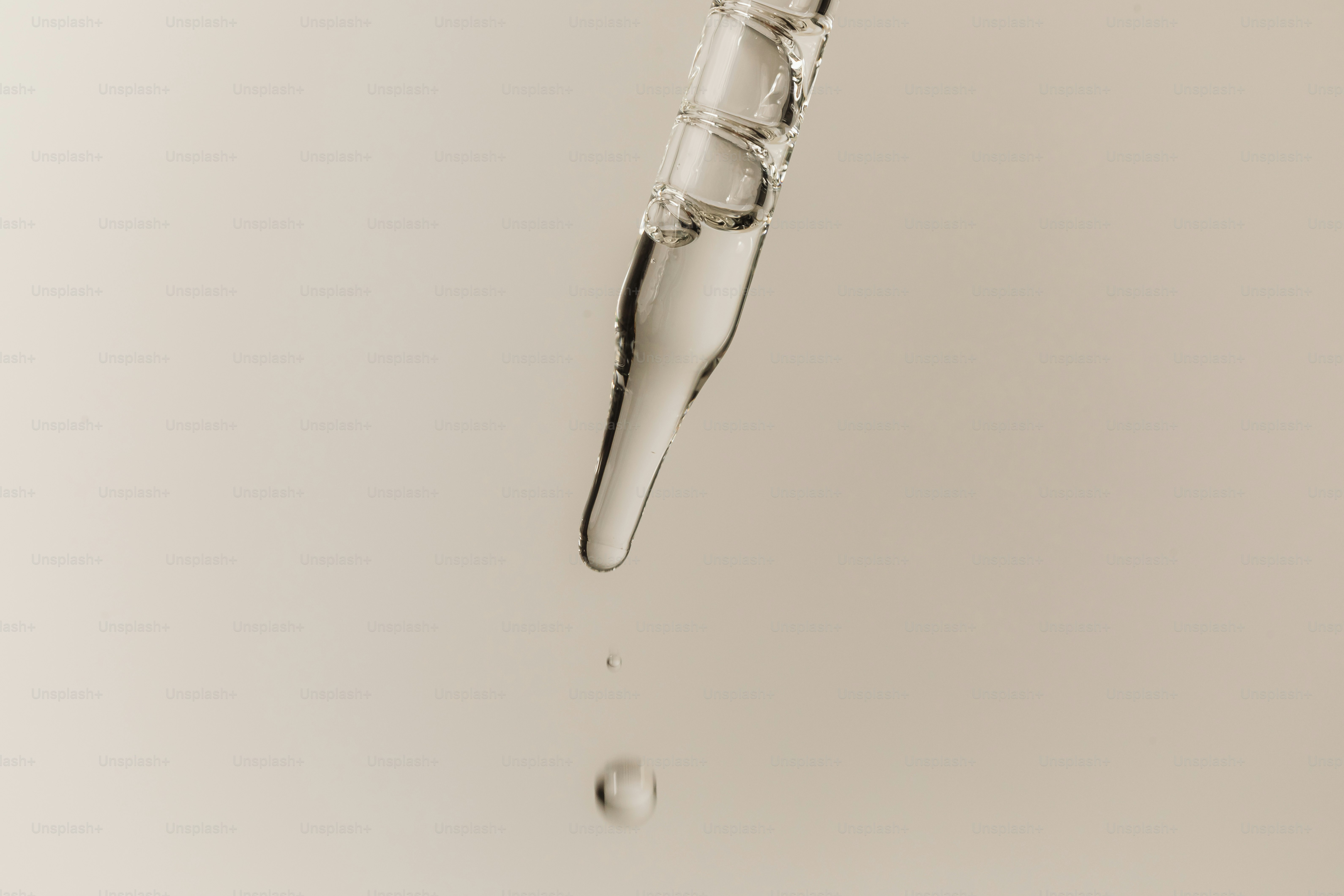 Un liquide clair s’écoule d’un compte-gouttes en verre.