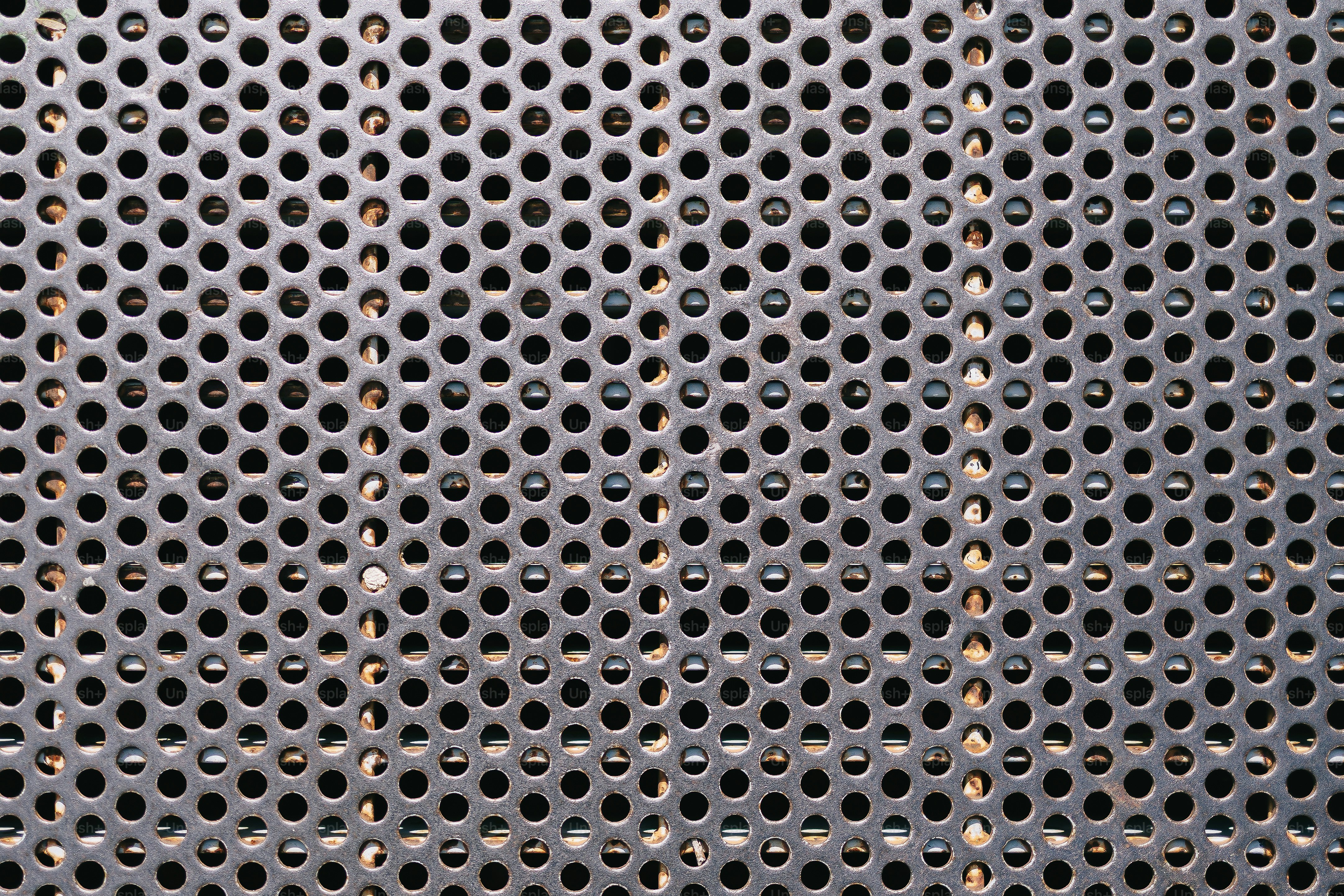 Primer plano de una superficie metálica texturizada con muchos agujeros.  foto – Imagen de Fondo en Unsplash, image size:3000x2000