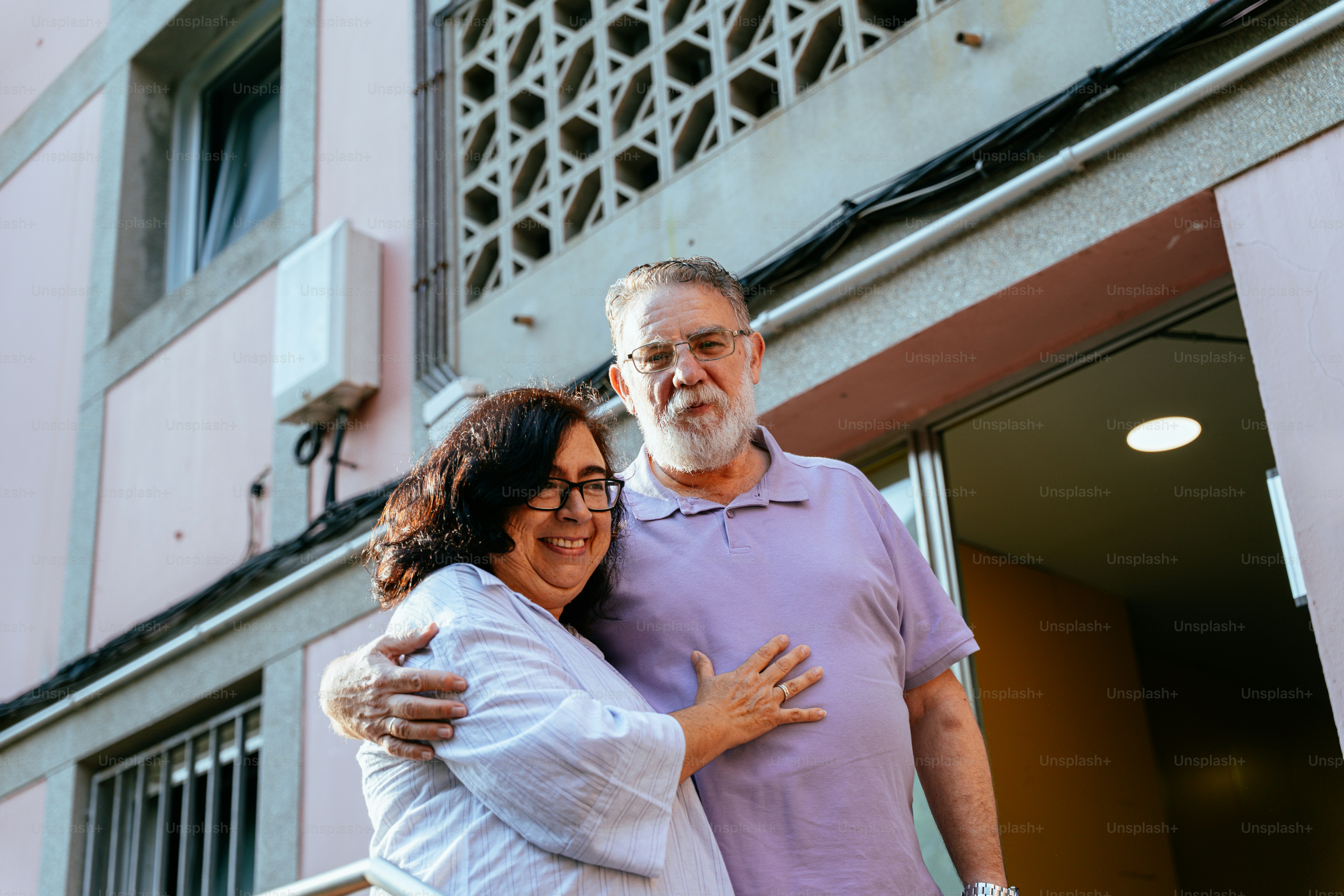 Elderly couple smiling outside building entrance