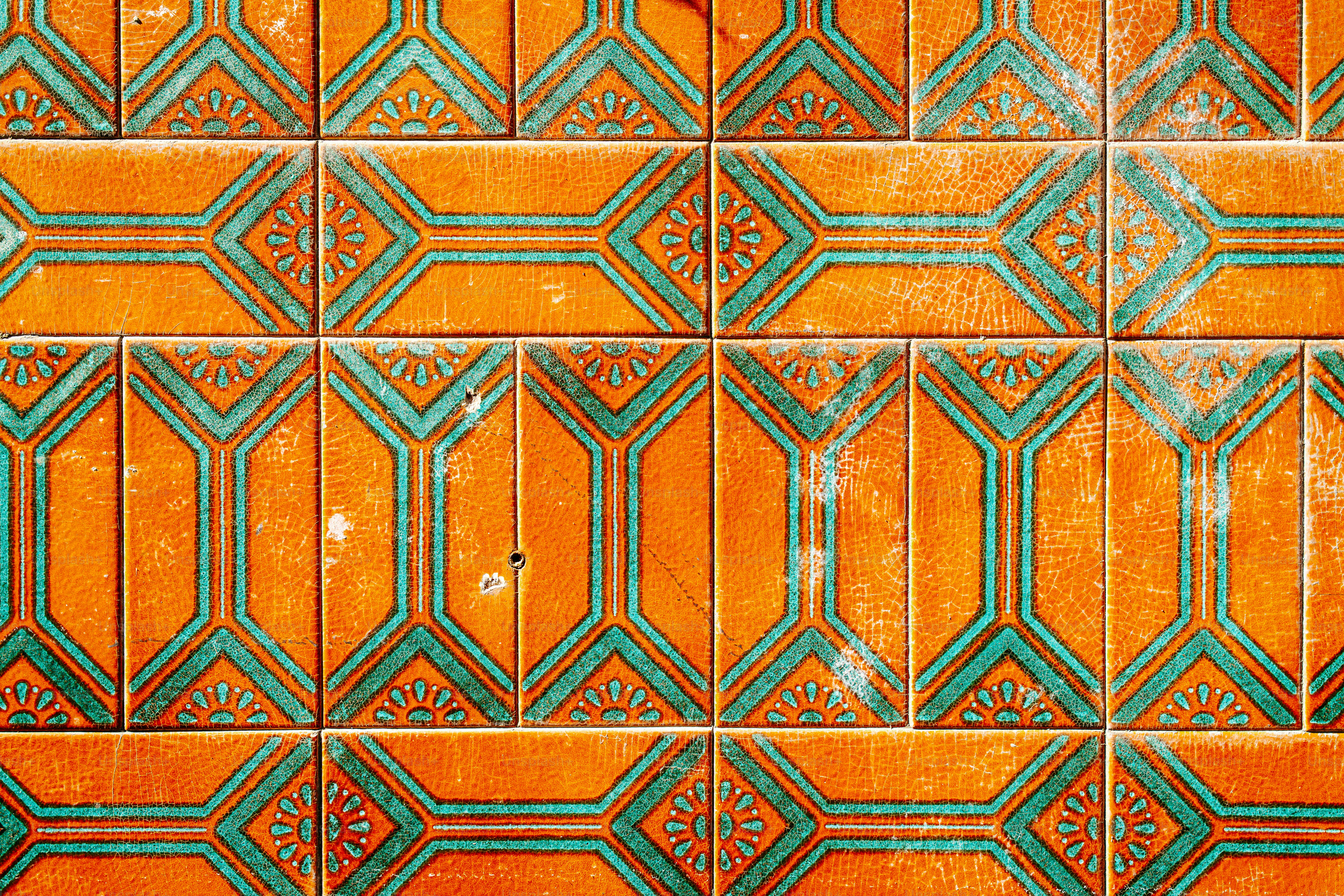 Azulejos naranjas con patrones geométricos verde azulado