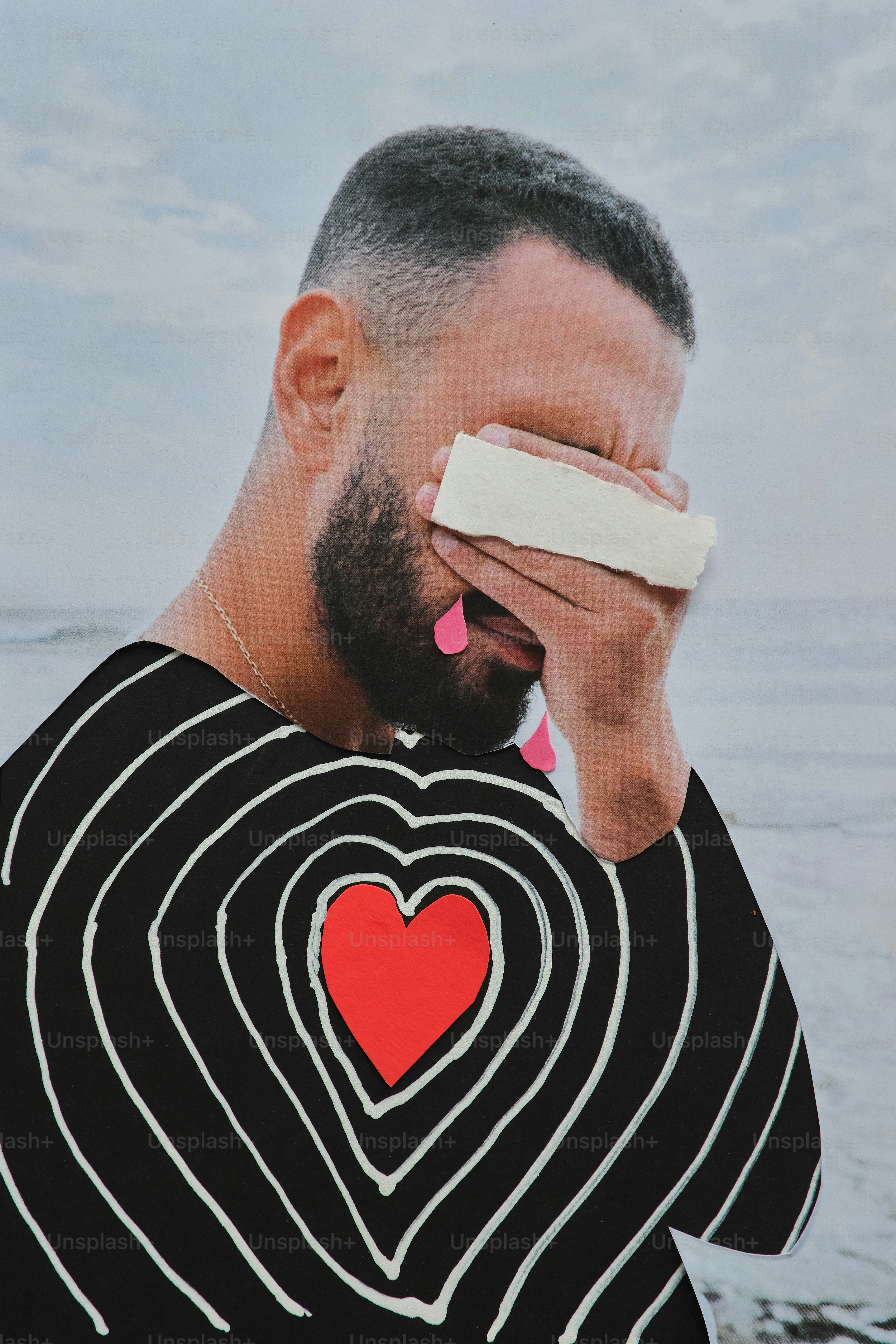 Man with heart design crying on beach