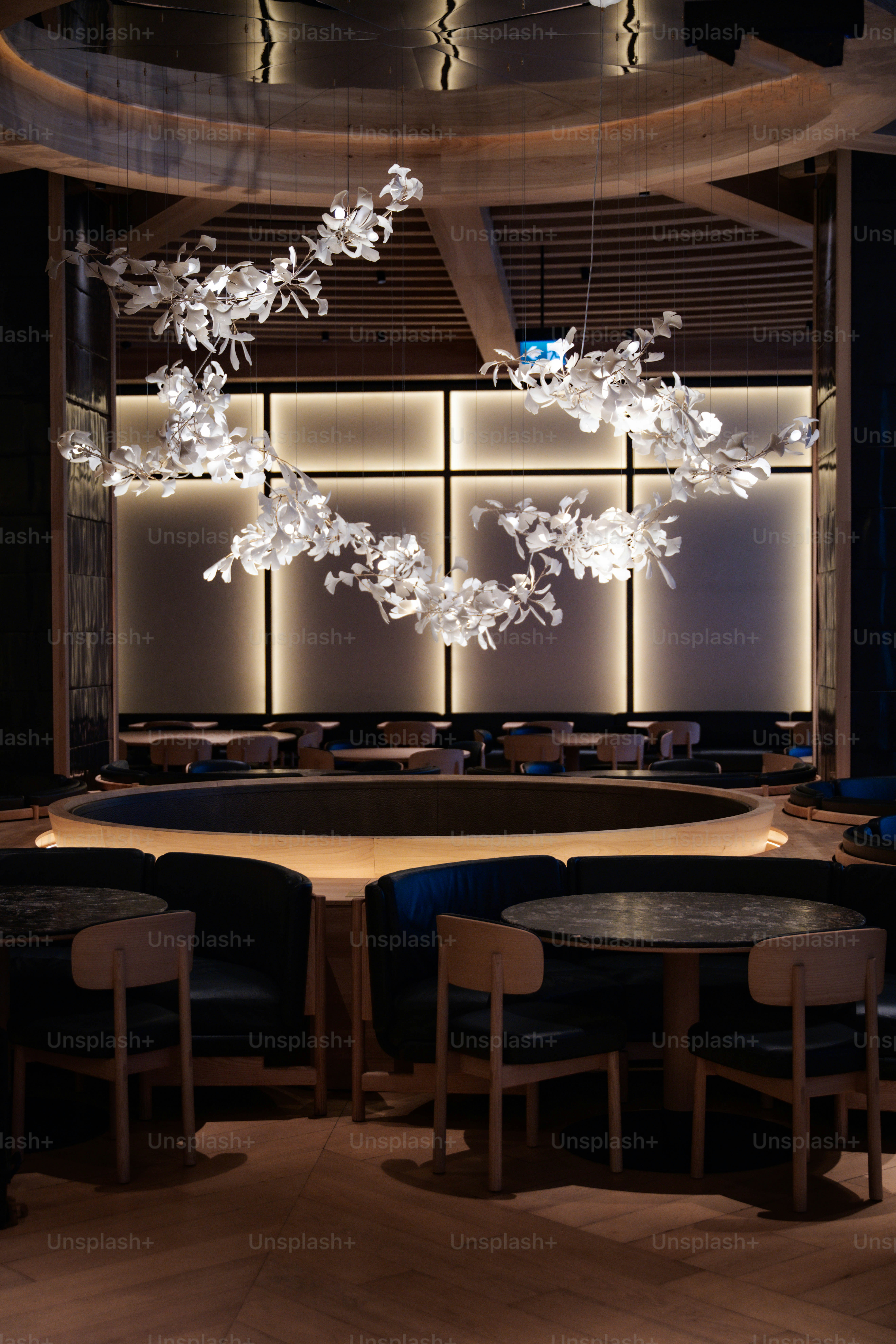 Elegant dining room with circular seating and modern chandelier.