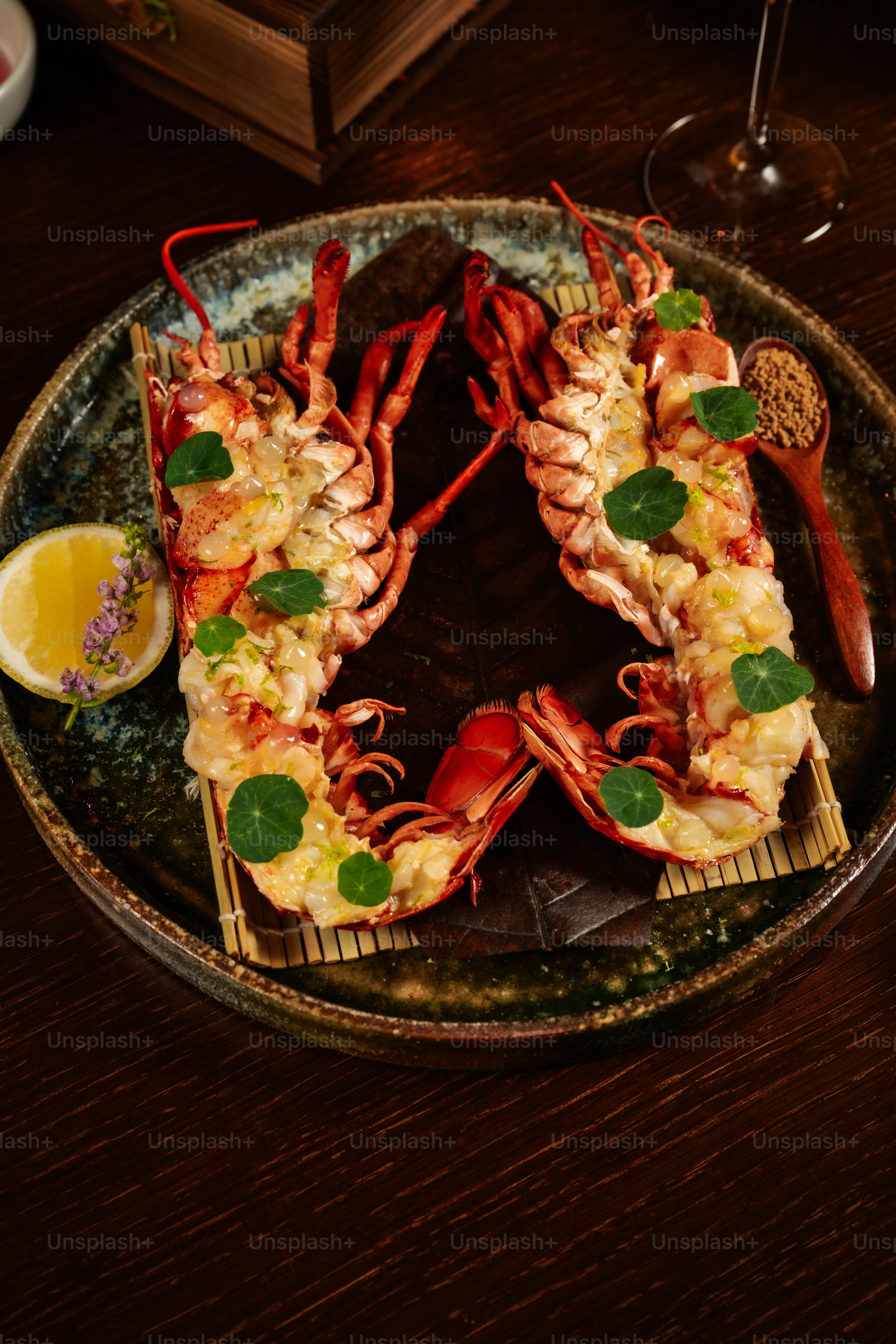 Two grilled lobsters served with lemon and herbs