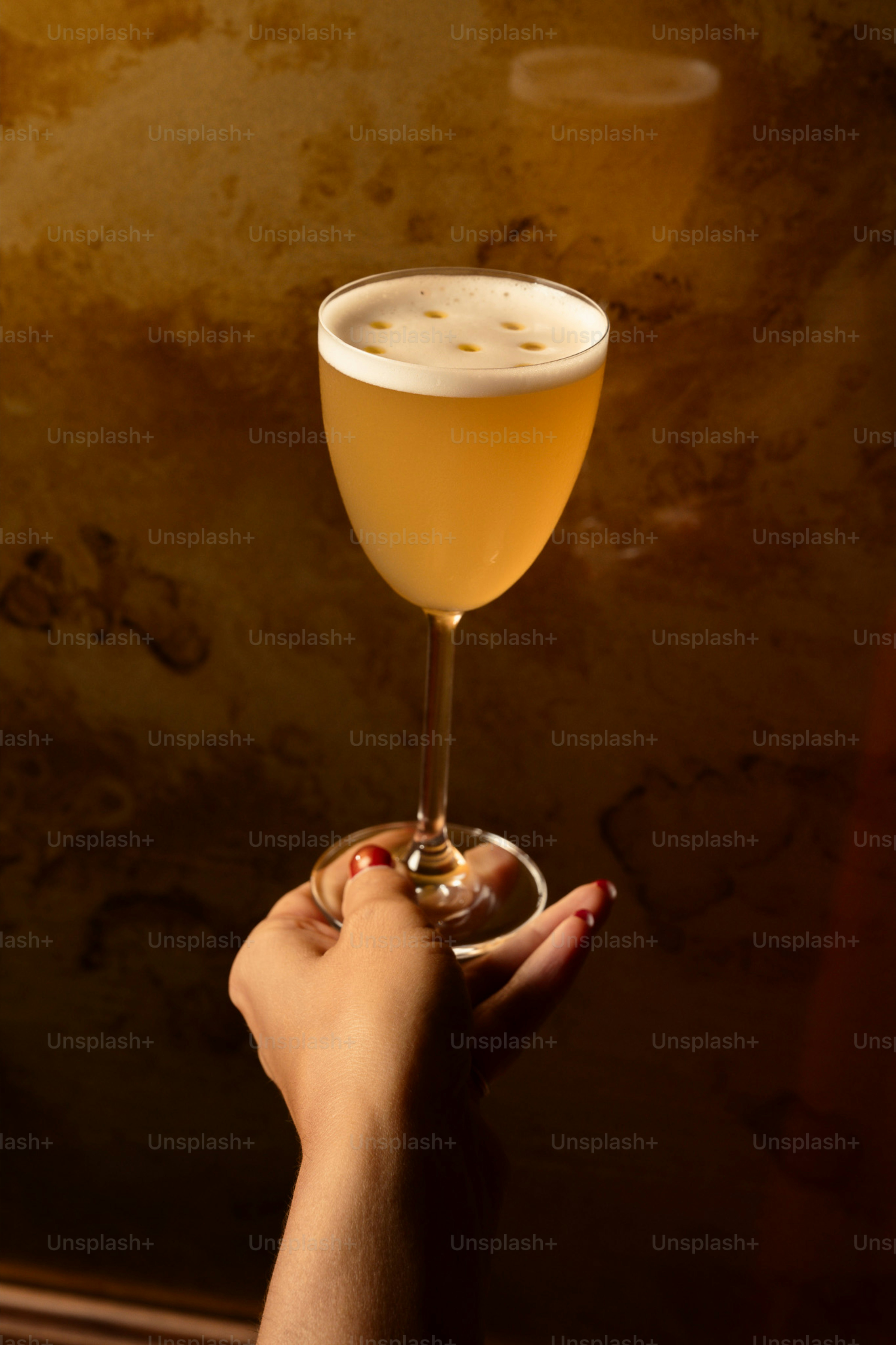 Hand holding a frothy cocktail with seven dots photo – Party Image on ...