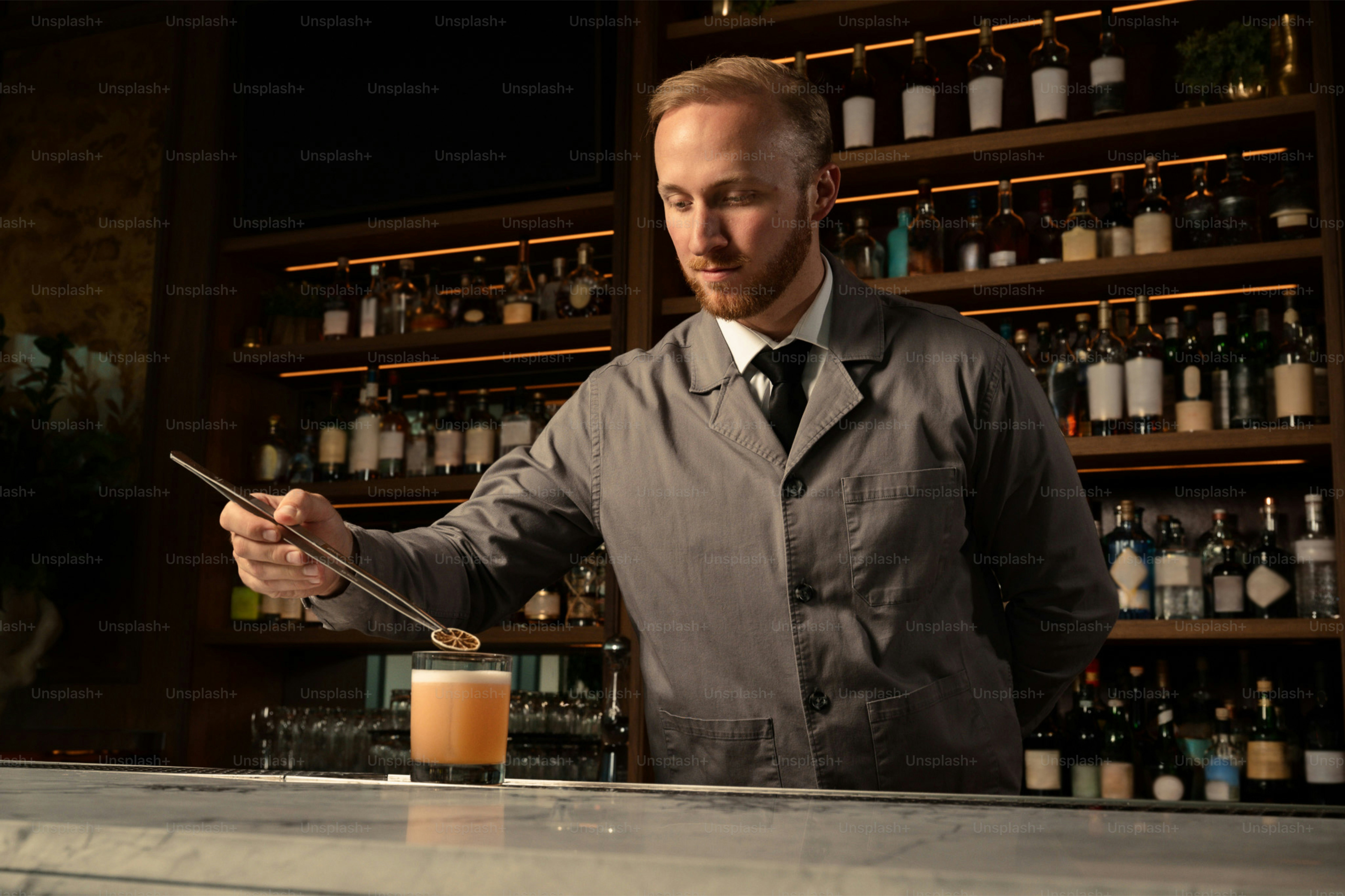 Bartender garnishing a cocktail behind a bar photo – Bar Image on Unsplash