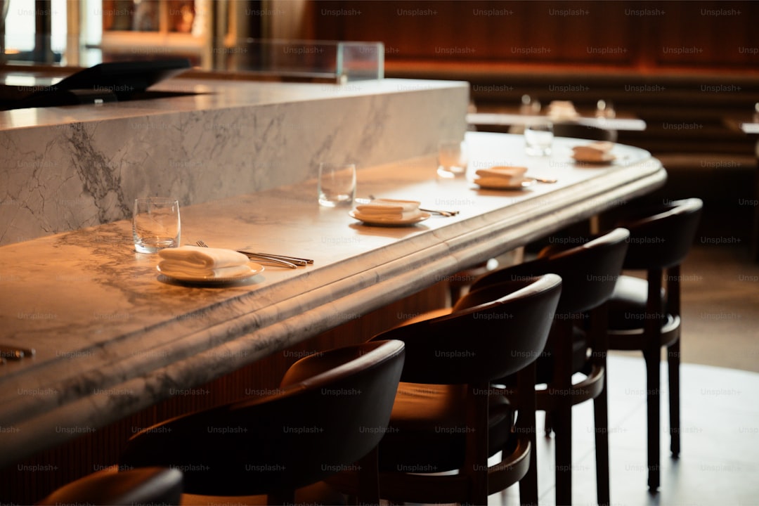 A modern bar with marble countertop and seating.
