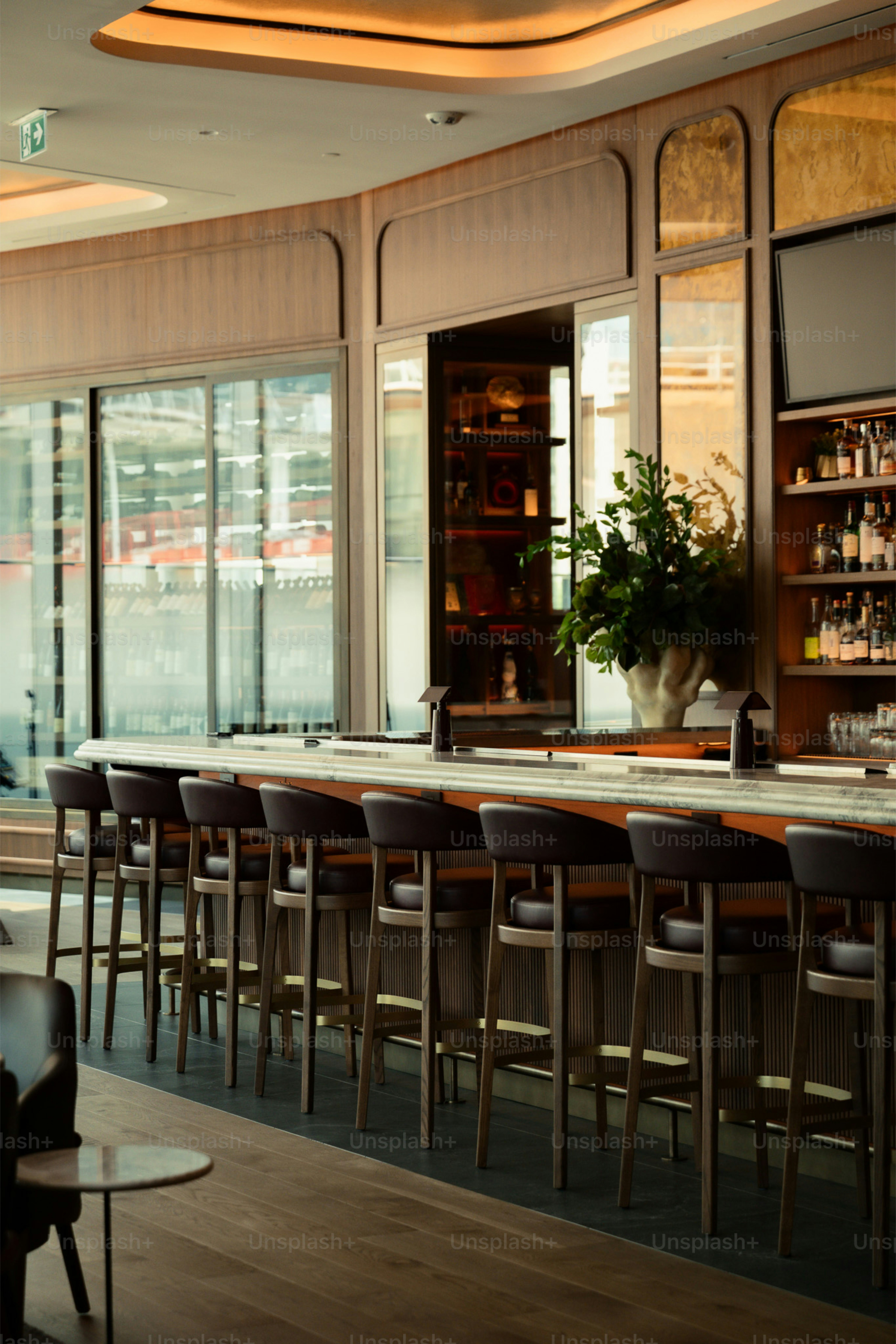 Modern bar with leather stools and wooden accents