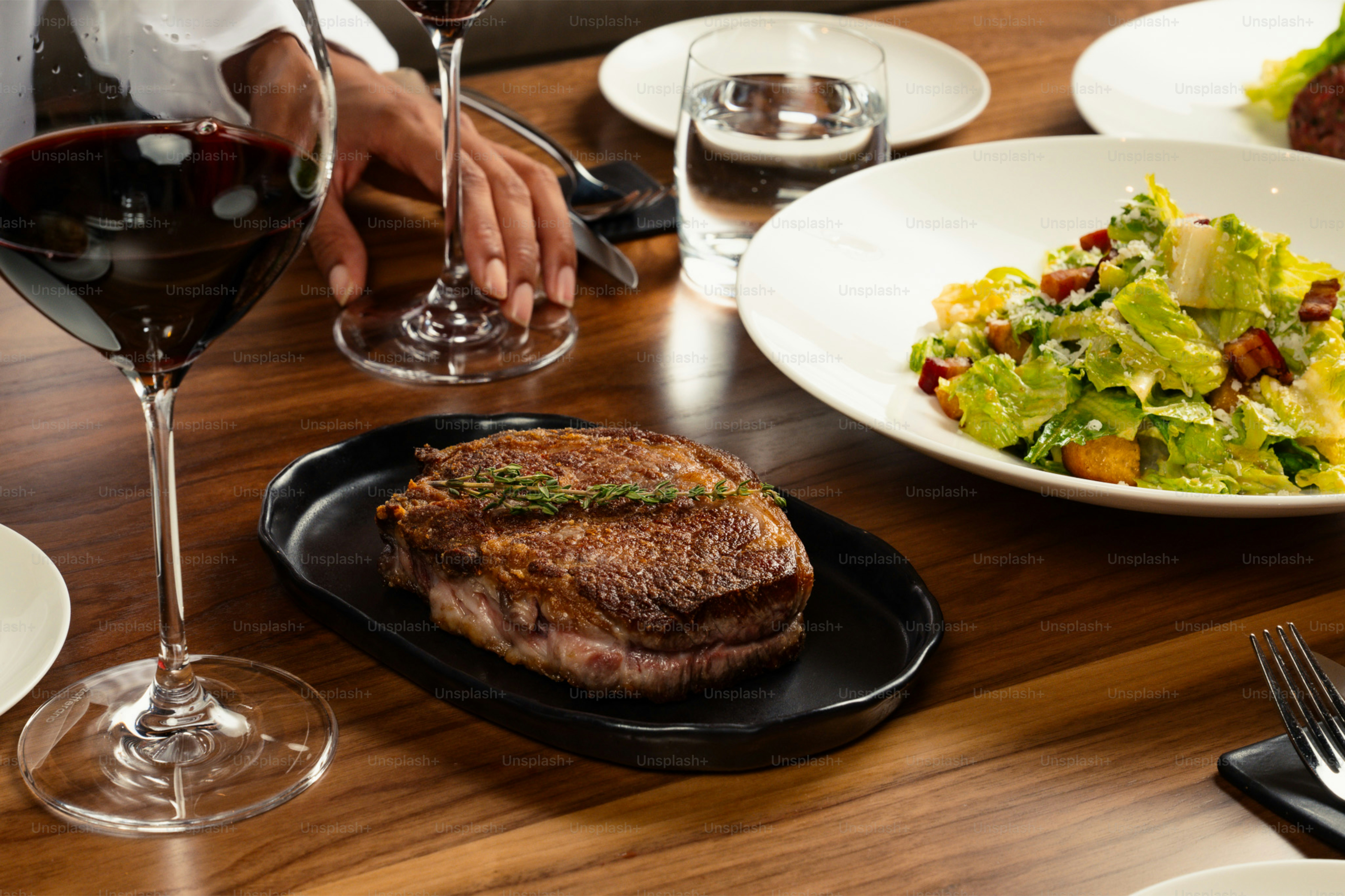 A grilled steak and salad served at a table.
