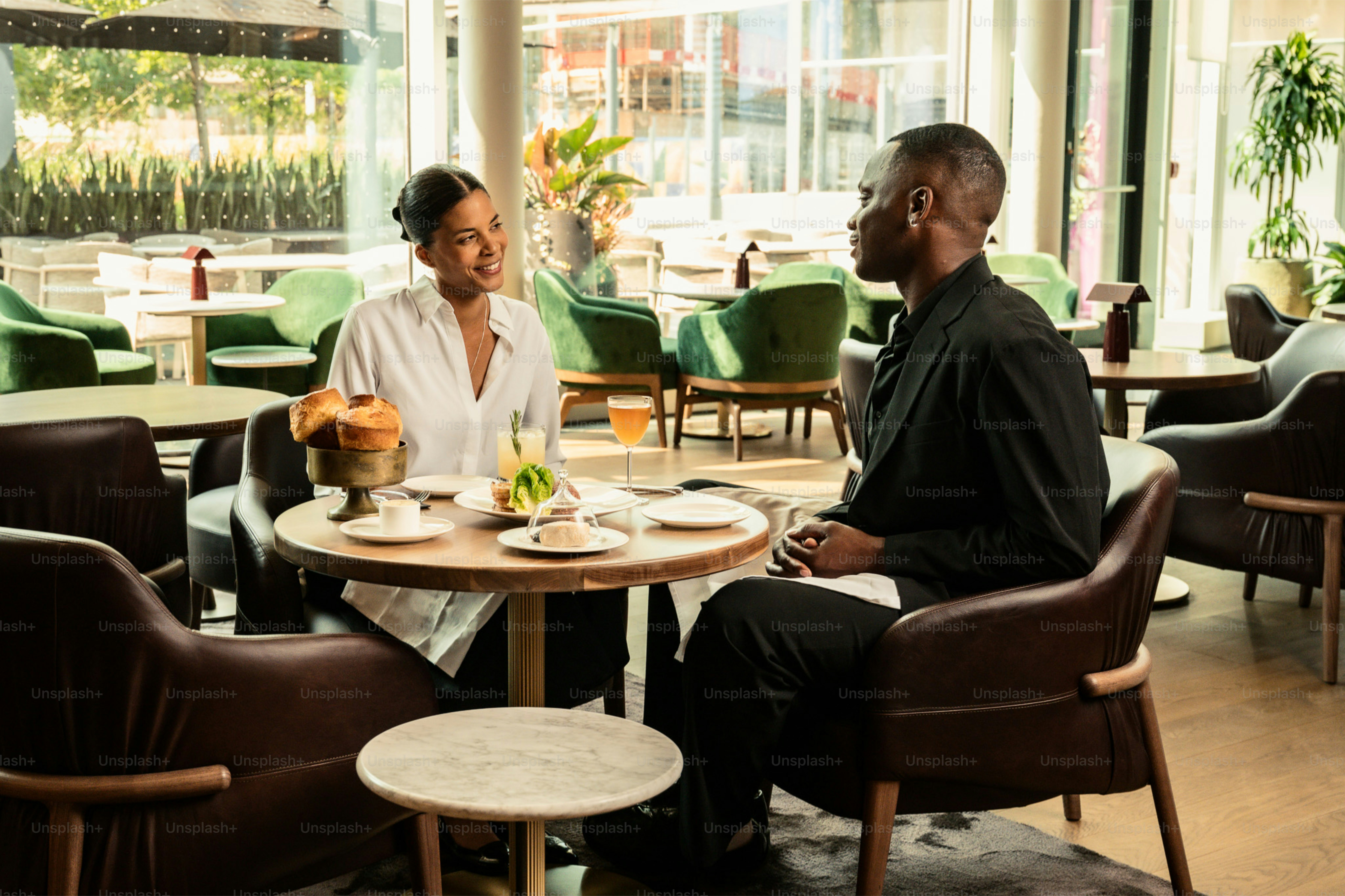 Two people talking at a table in a cafe.