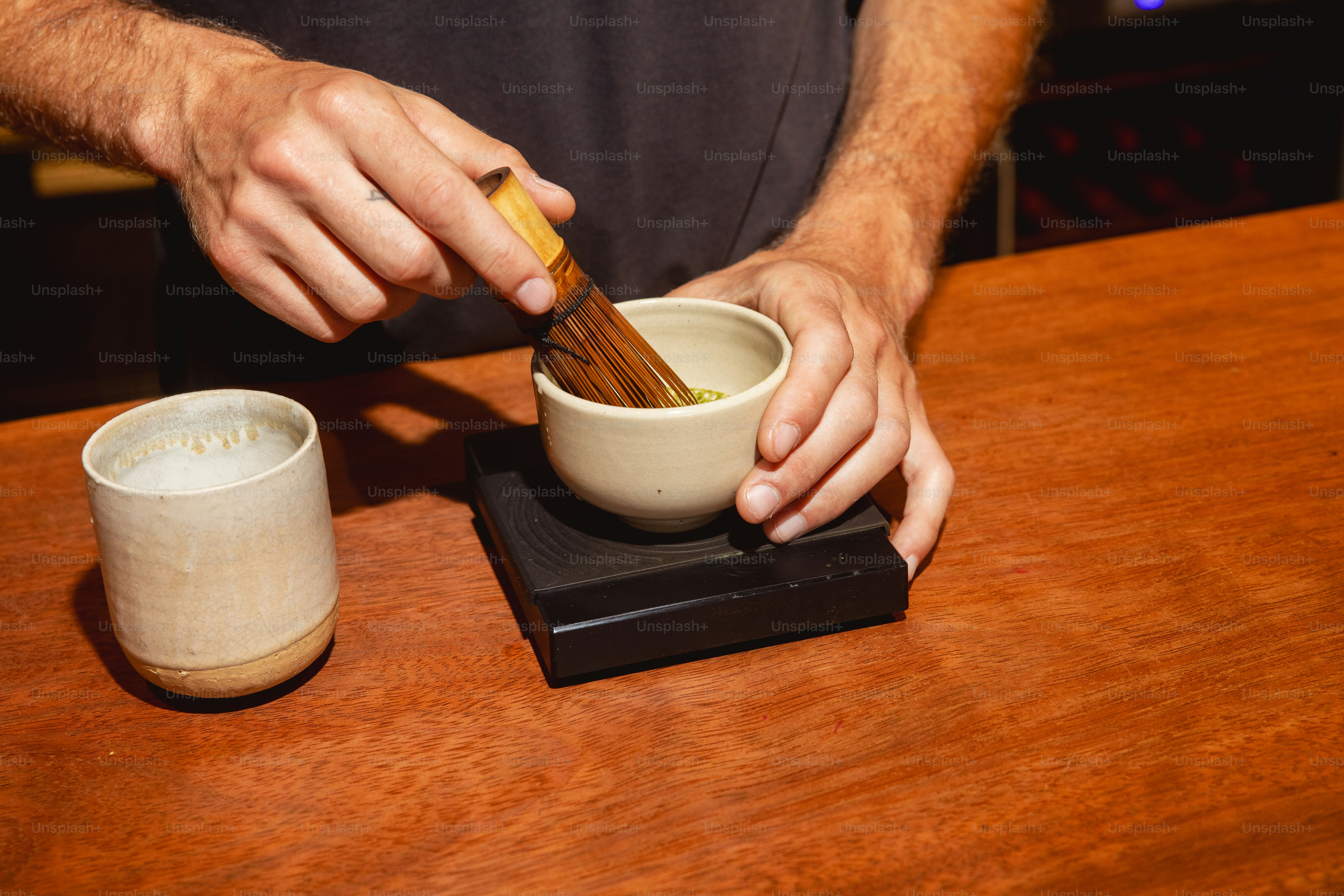 Hands whisking matcha tea in a bowl photo – Coffee Image on Unsplash