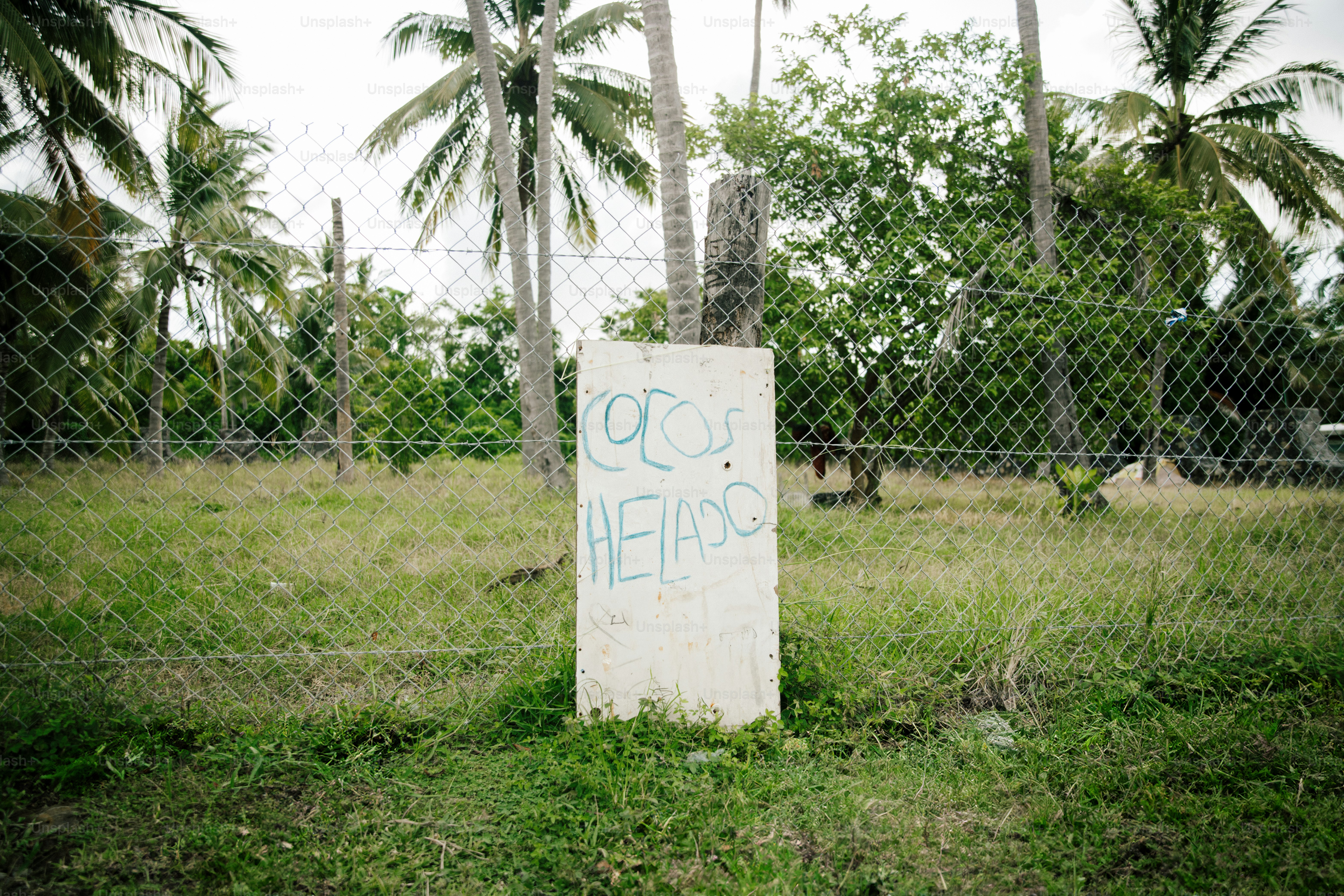 Concrete marker with graffiti behind a fence