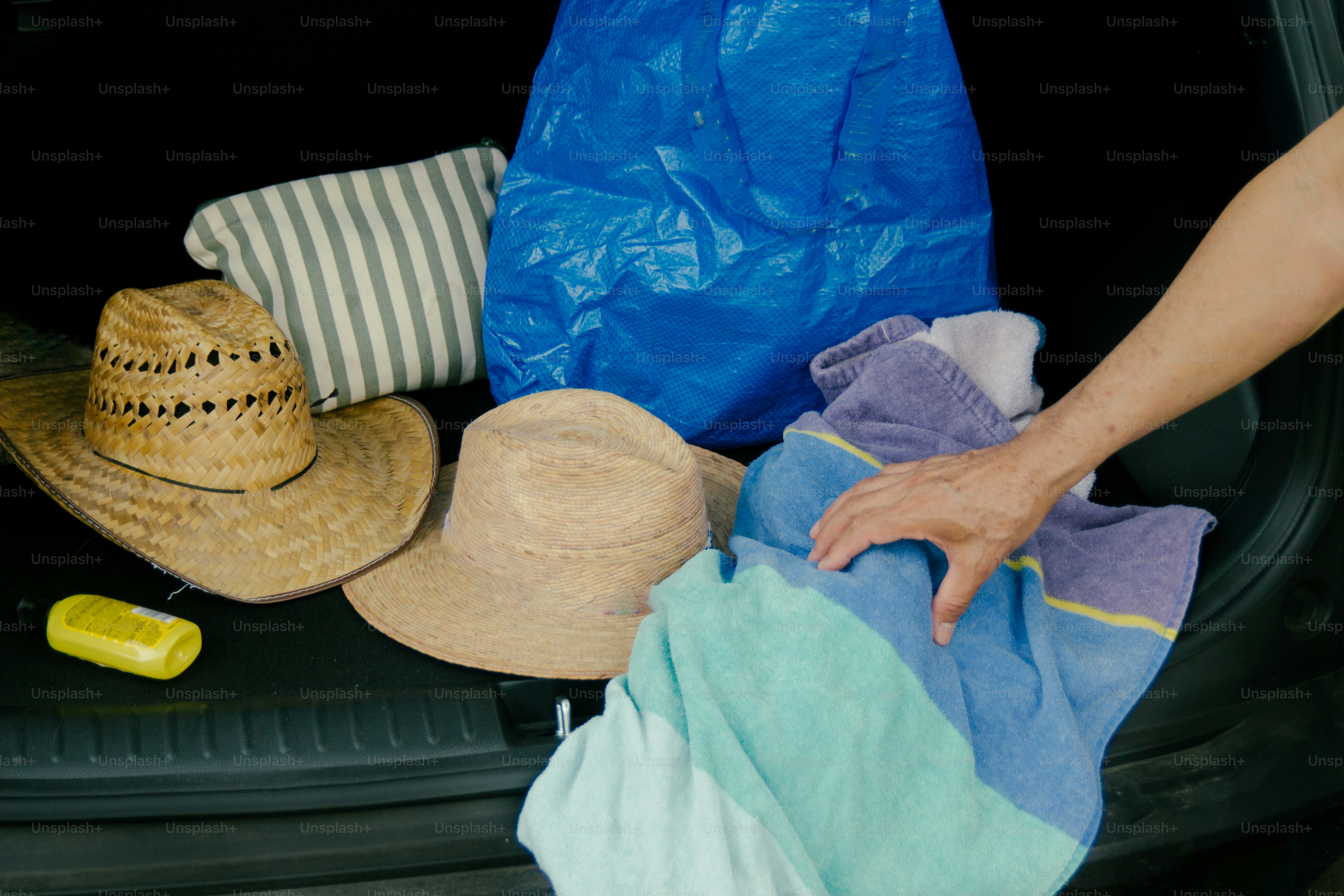 Hats and towels packed in car trunk for travel