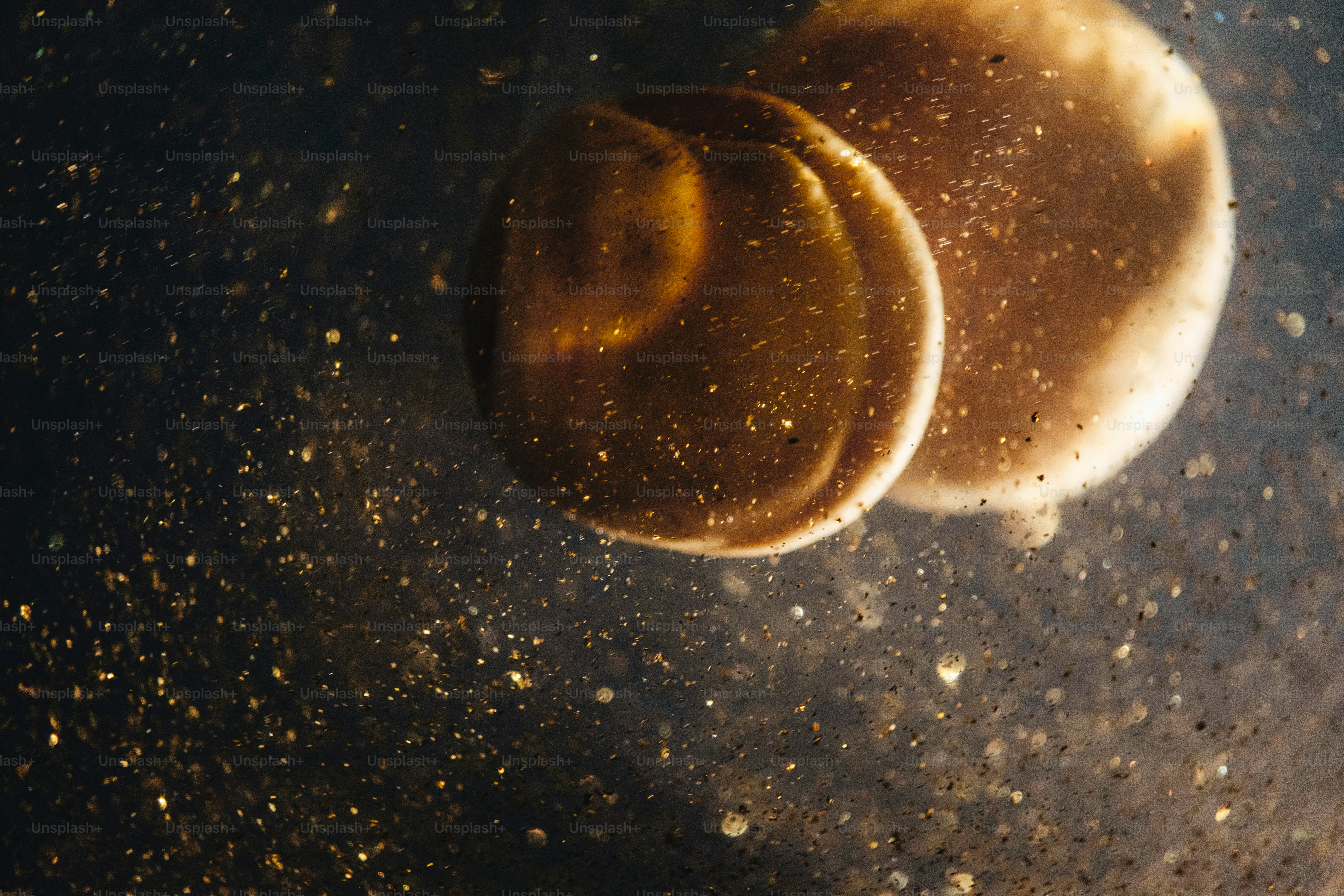 Two golden orbs with sparkling particles