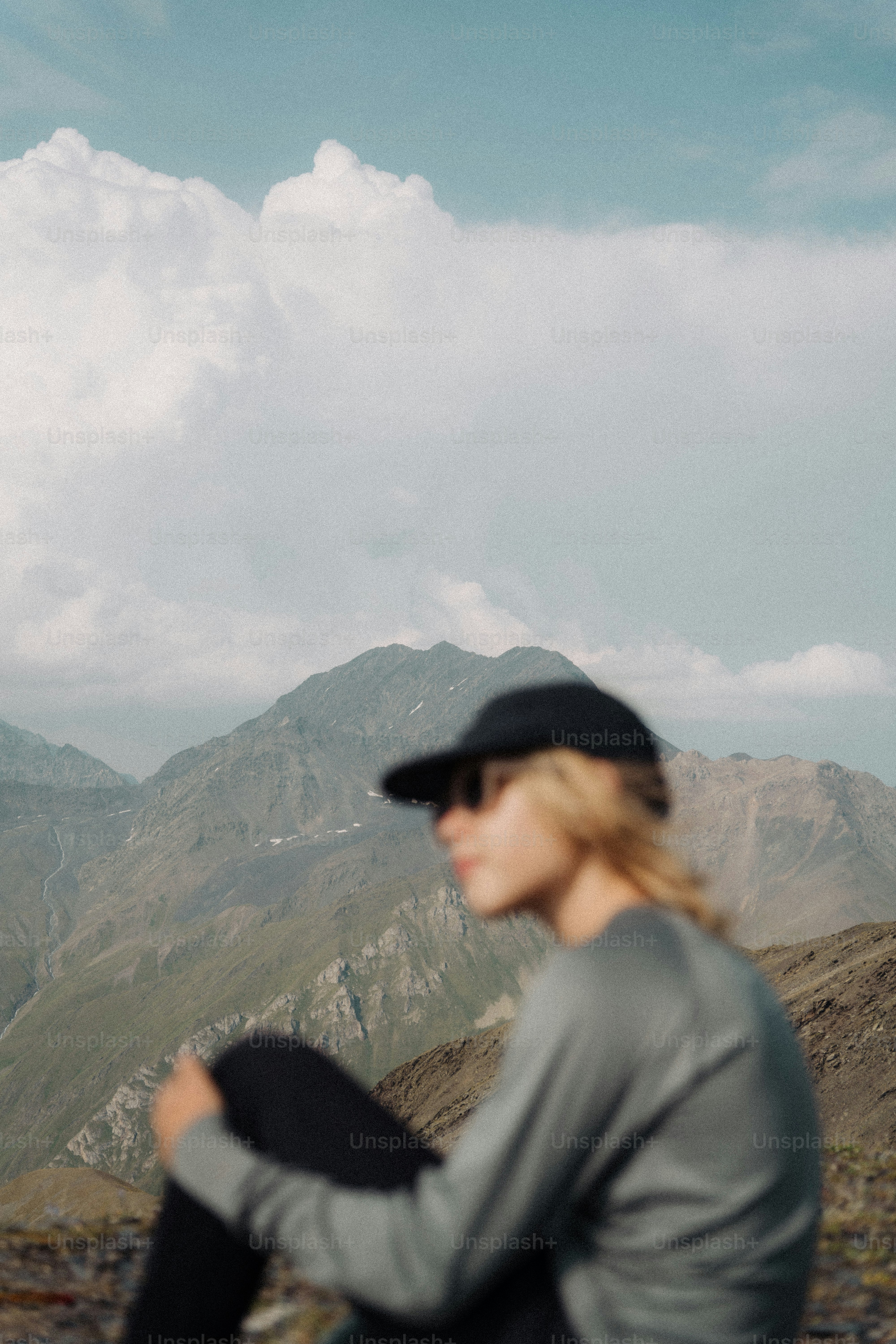Mulher no boné de beisebol que olha montanhas