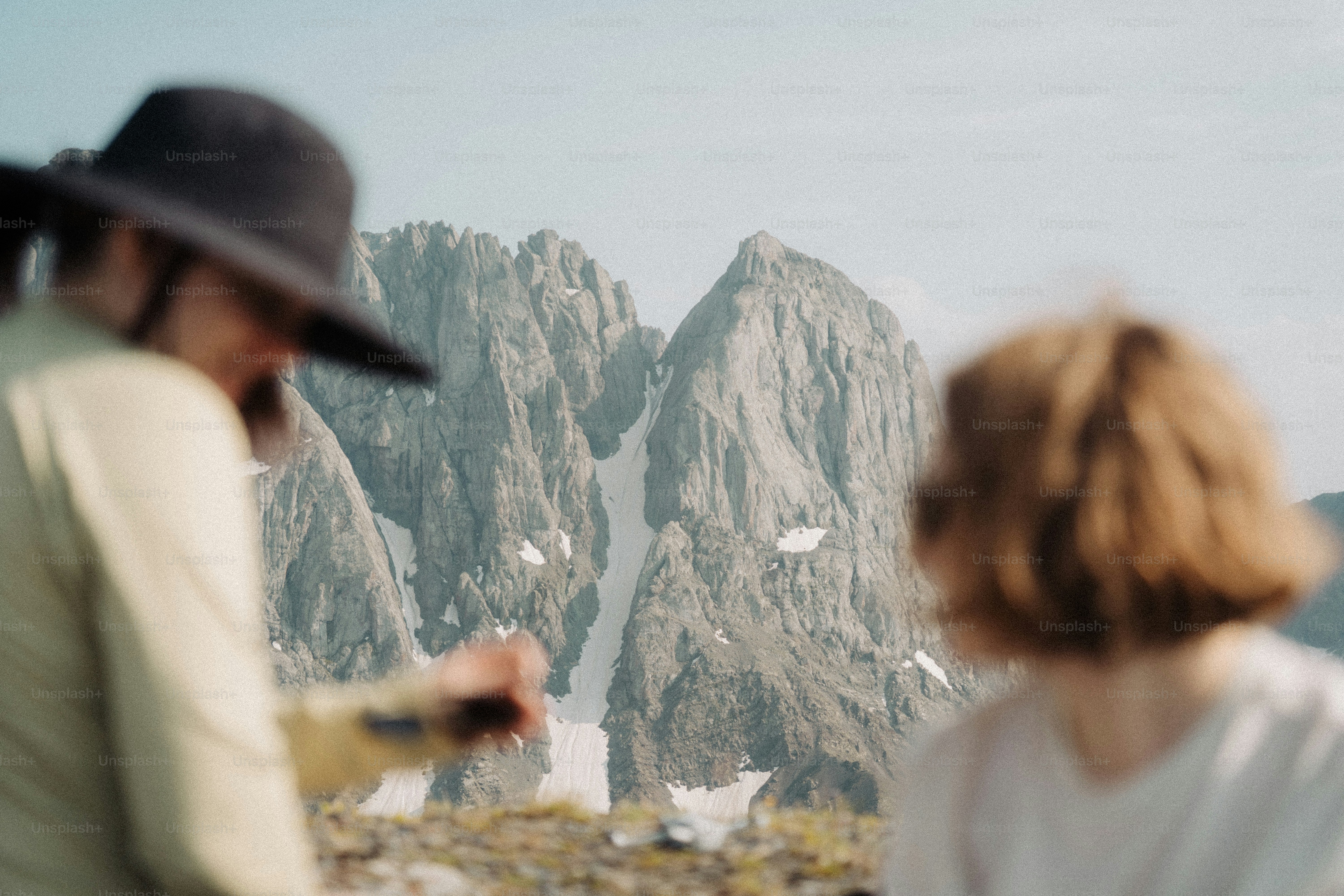 Duas pessoas admiram picos de montanhas irregulares