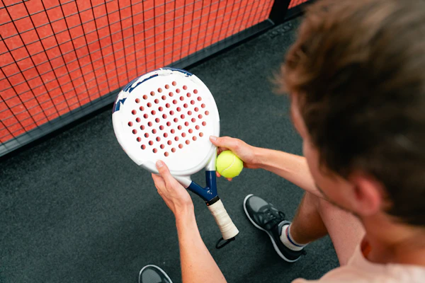 Man holding padel racket and ball
