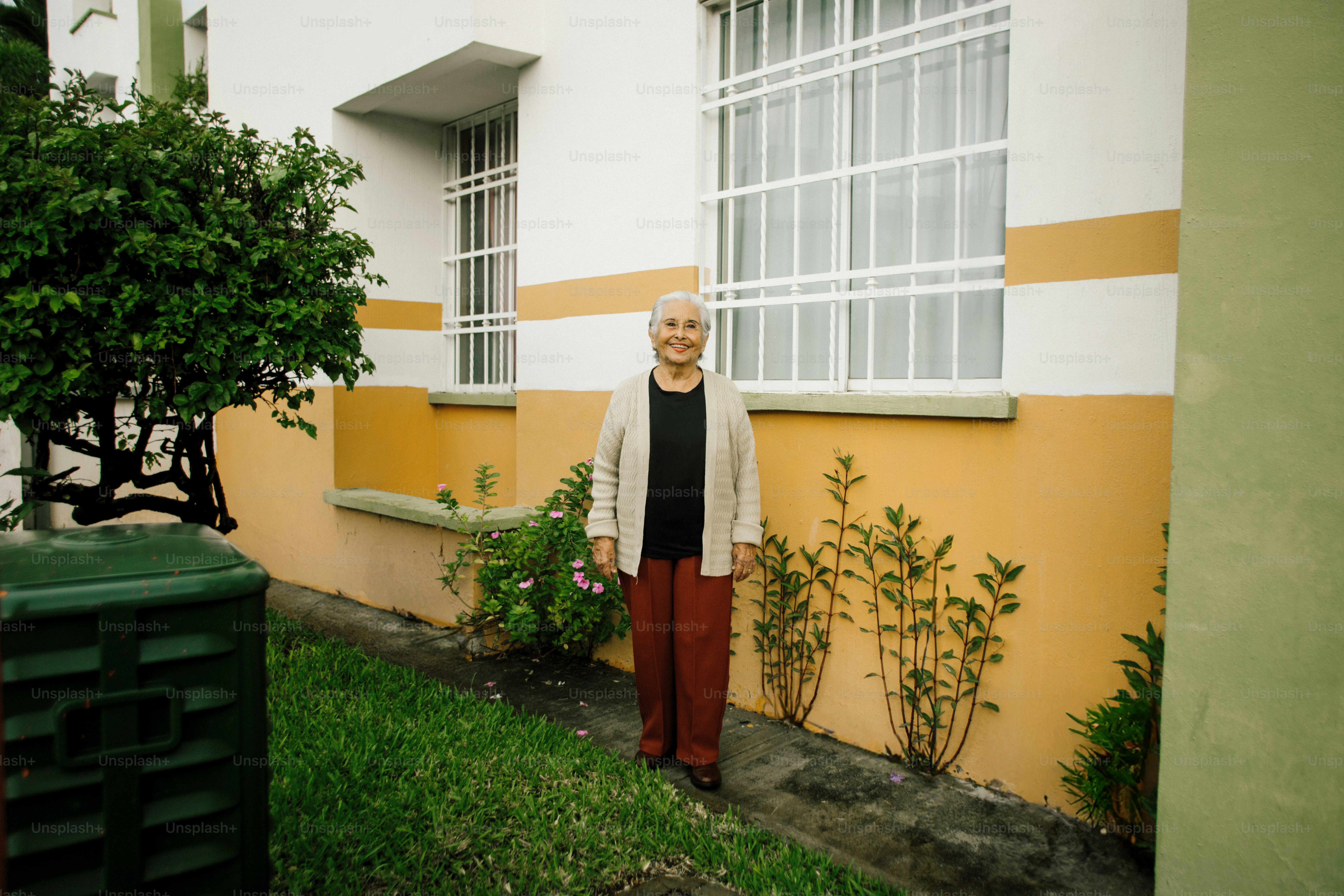 Elderly woman stands outside a building