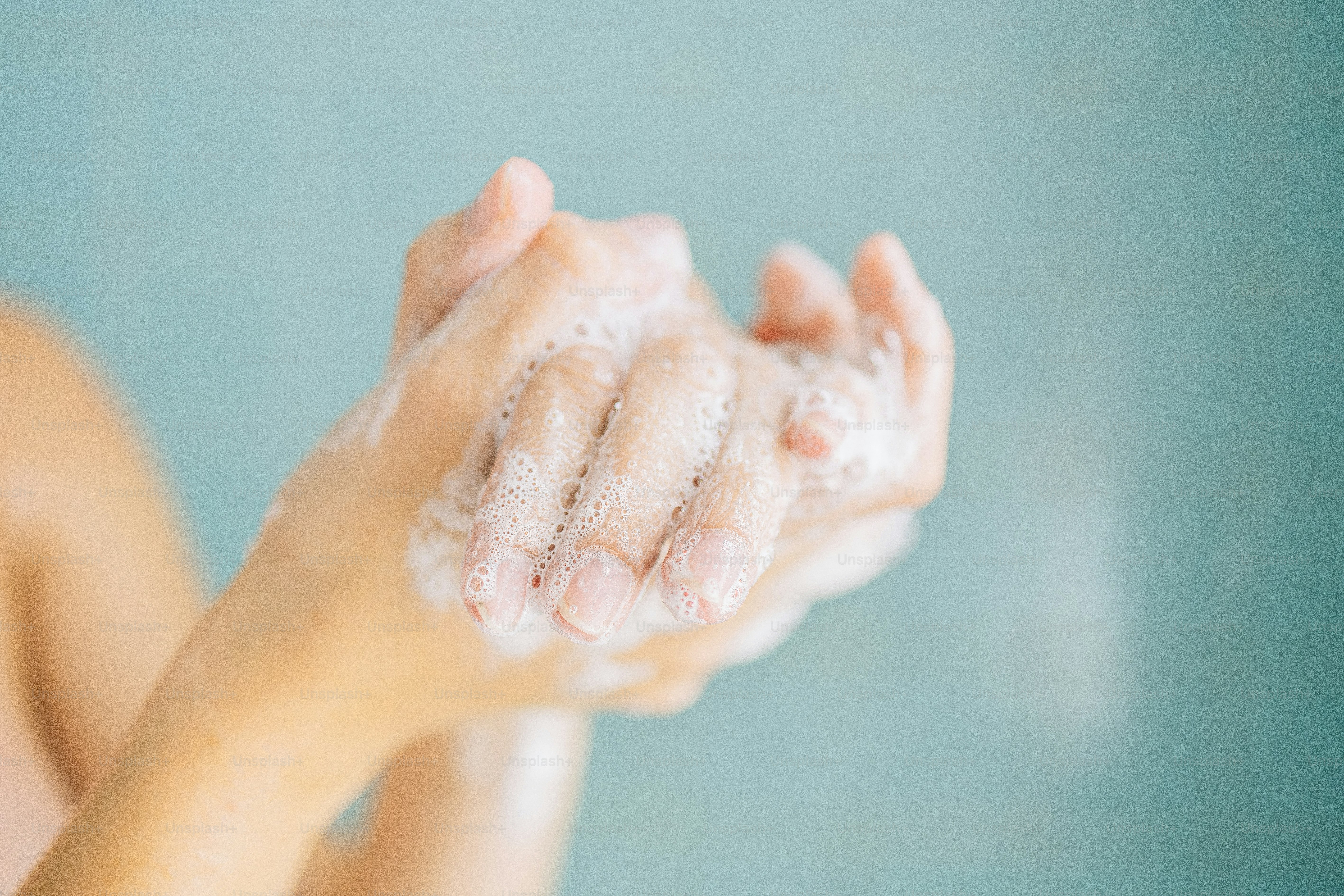 Nahaufnahme von Händen, die mit Wasser und Seife gewaschen werden.