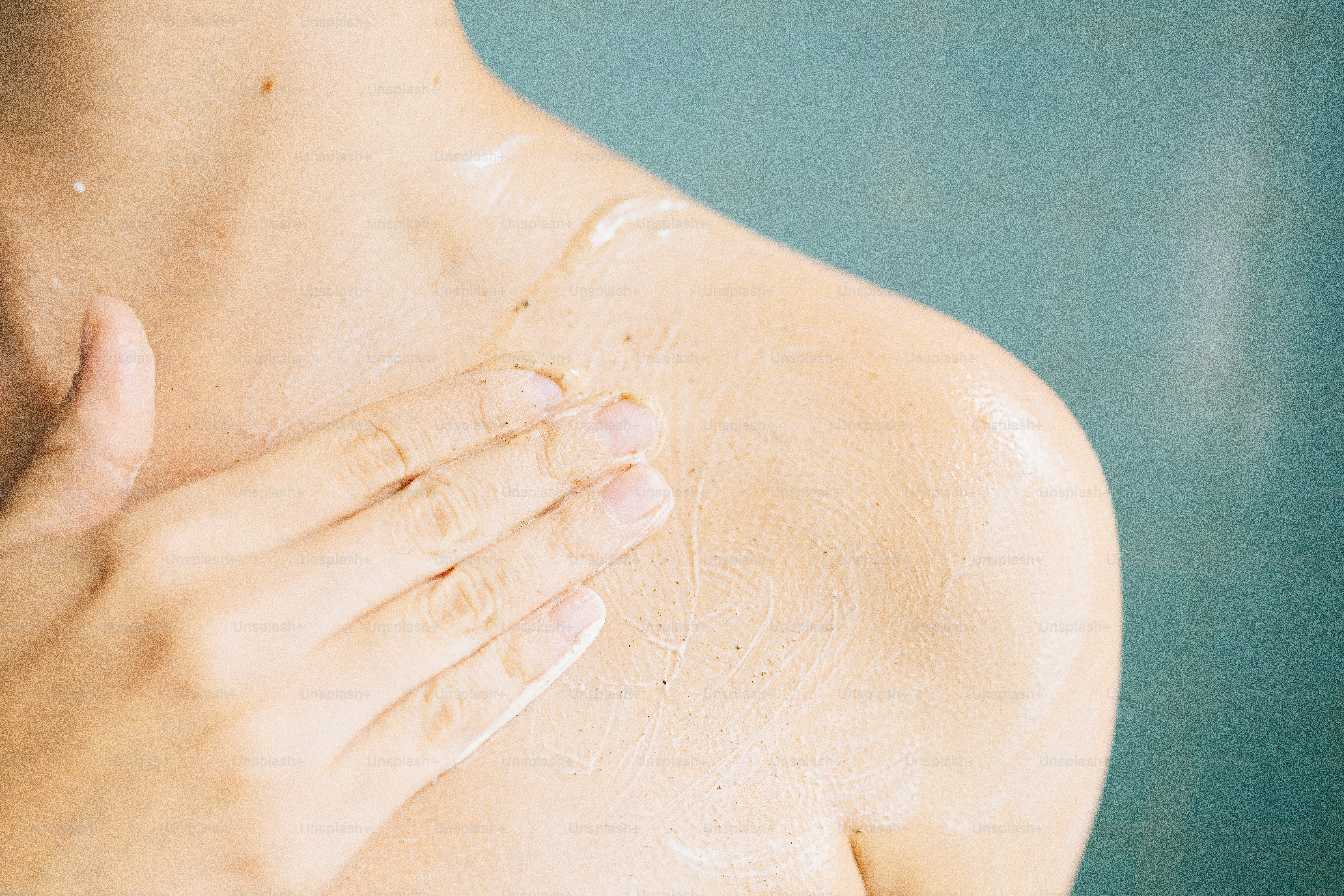 Person, die Körperpeeling auf die Schulter aufträgt