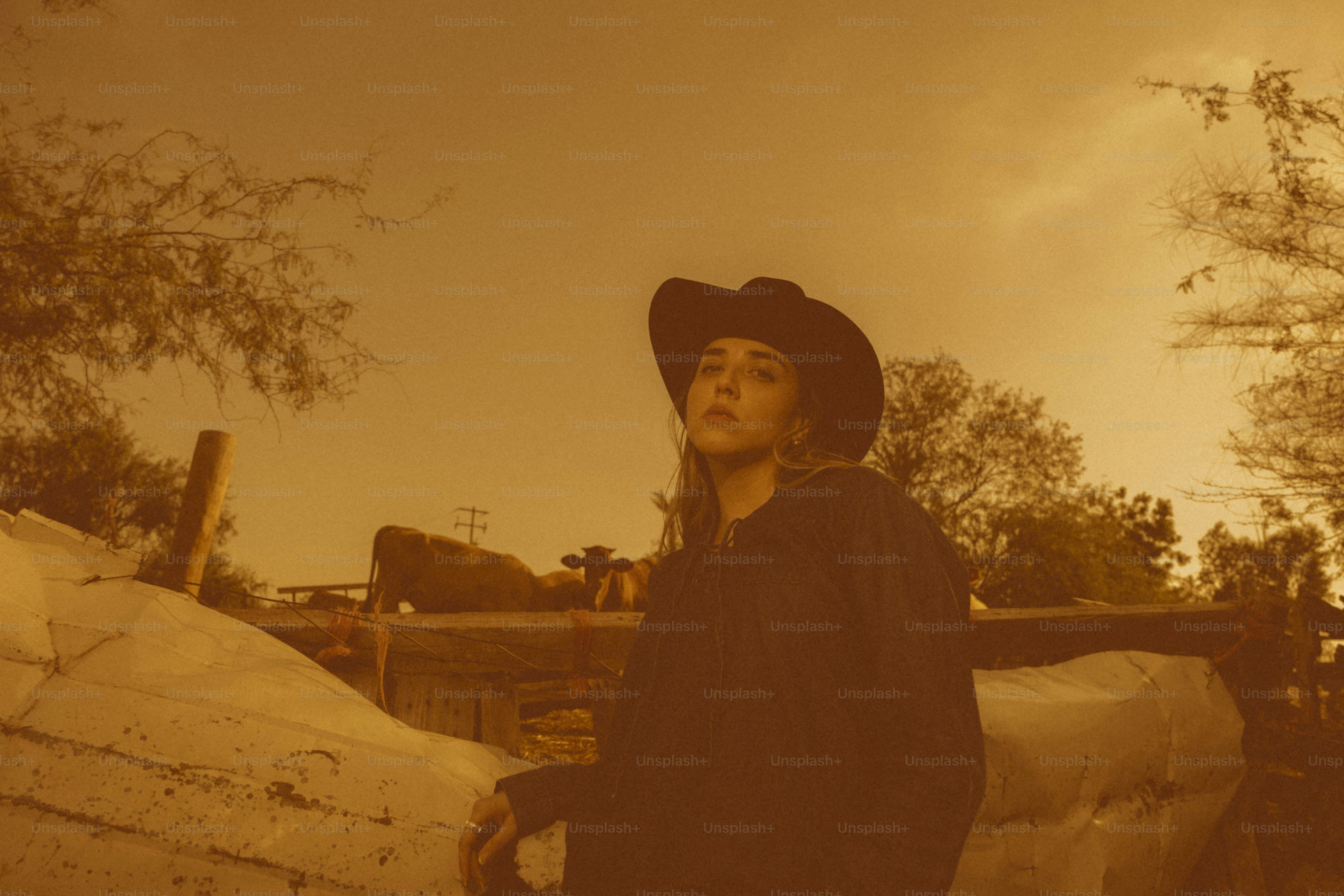 Woman in cowboy hat looks up at the sky