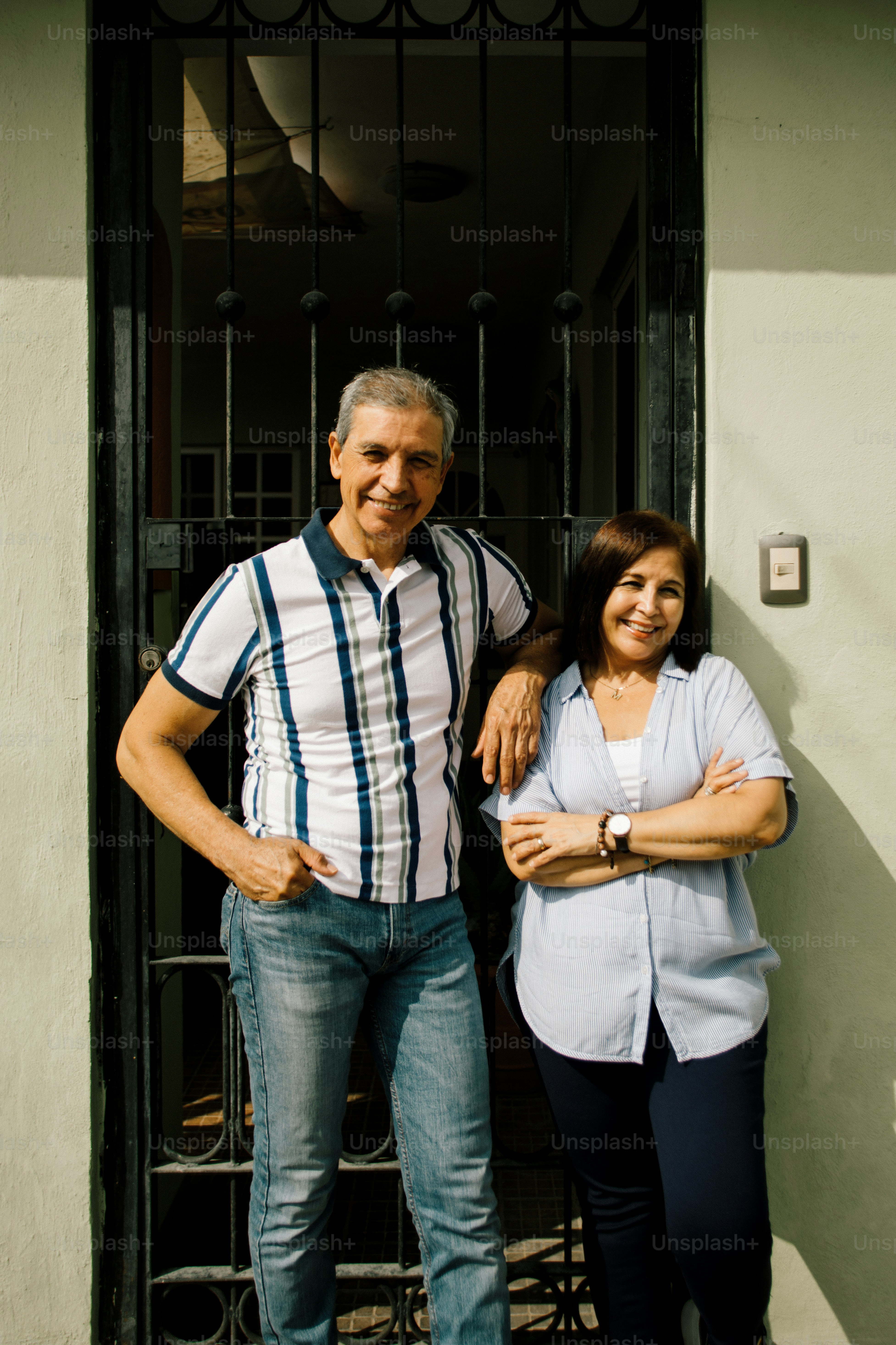 Smiling couple standing in front of a doorway.