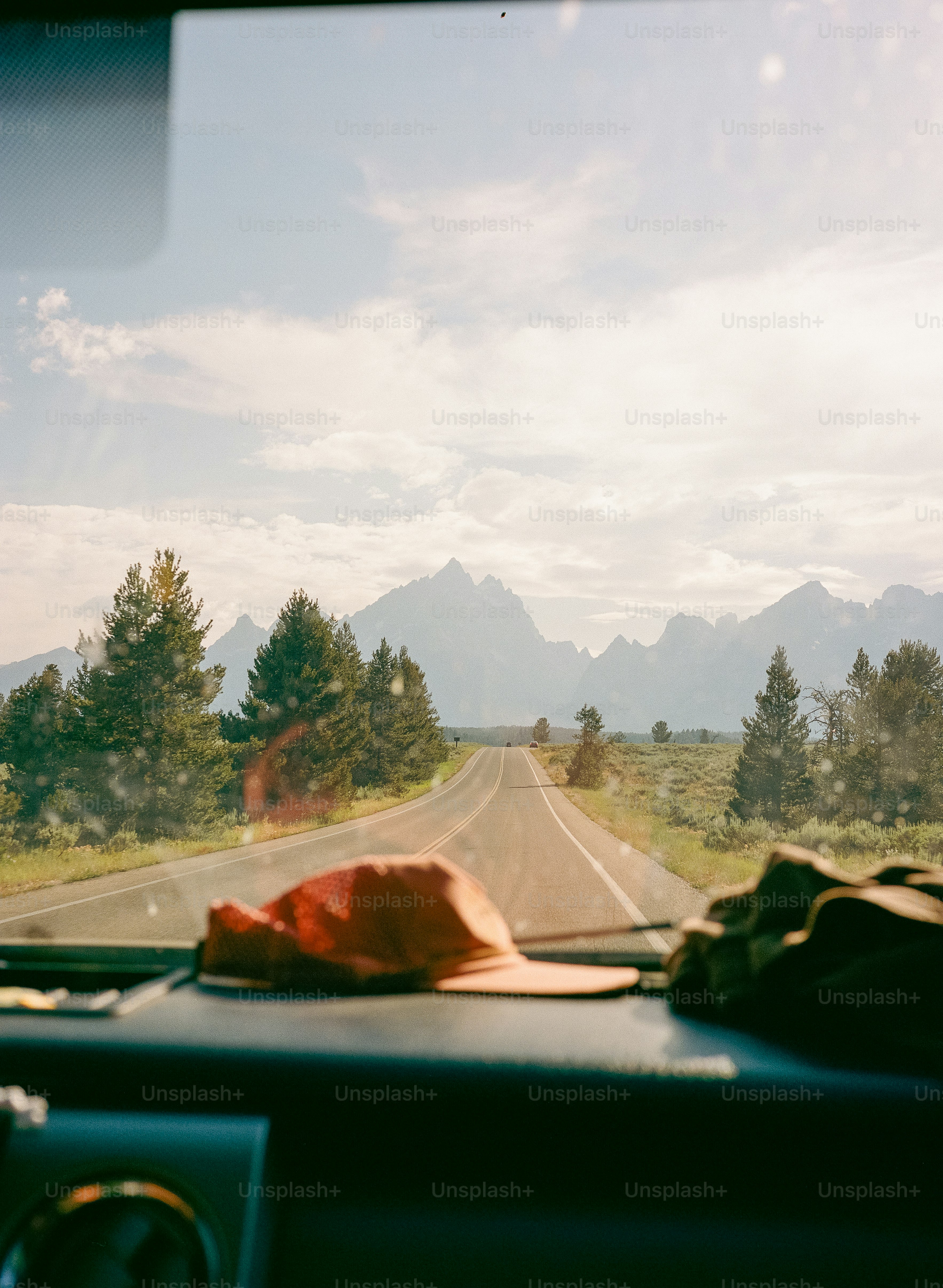 Straße, die zu Bergen mit Bäumen und Himmel führt