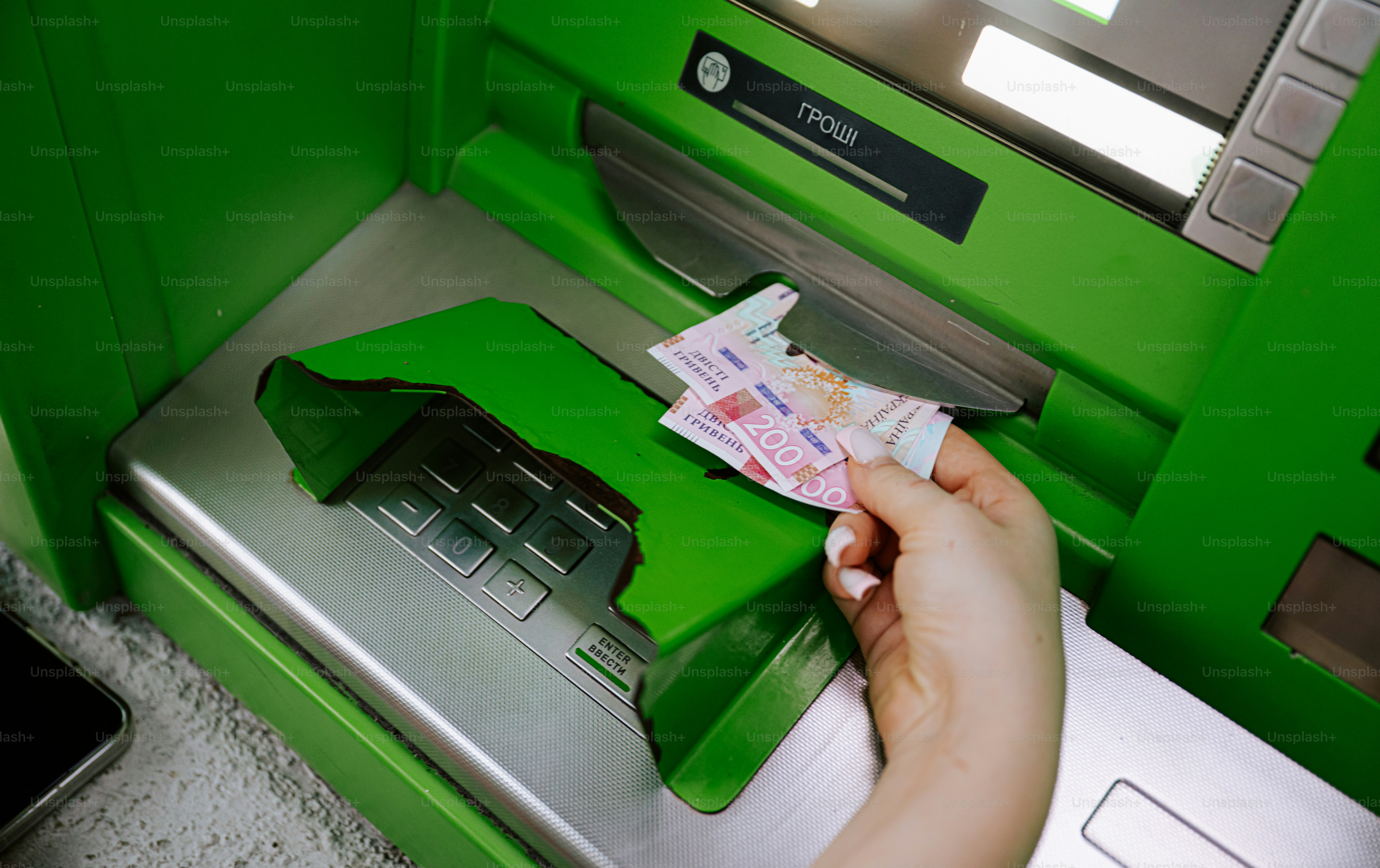 Hand inserting cash into an atm machine
