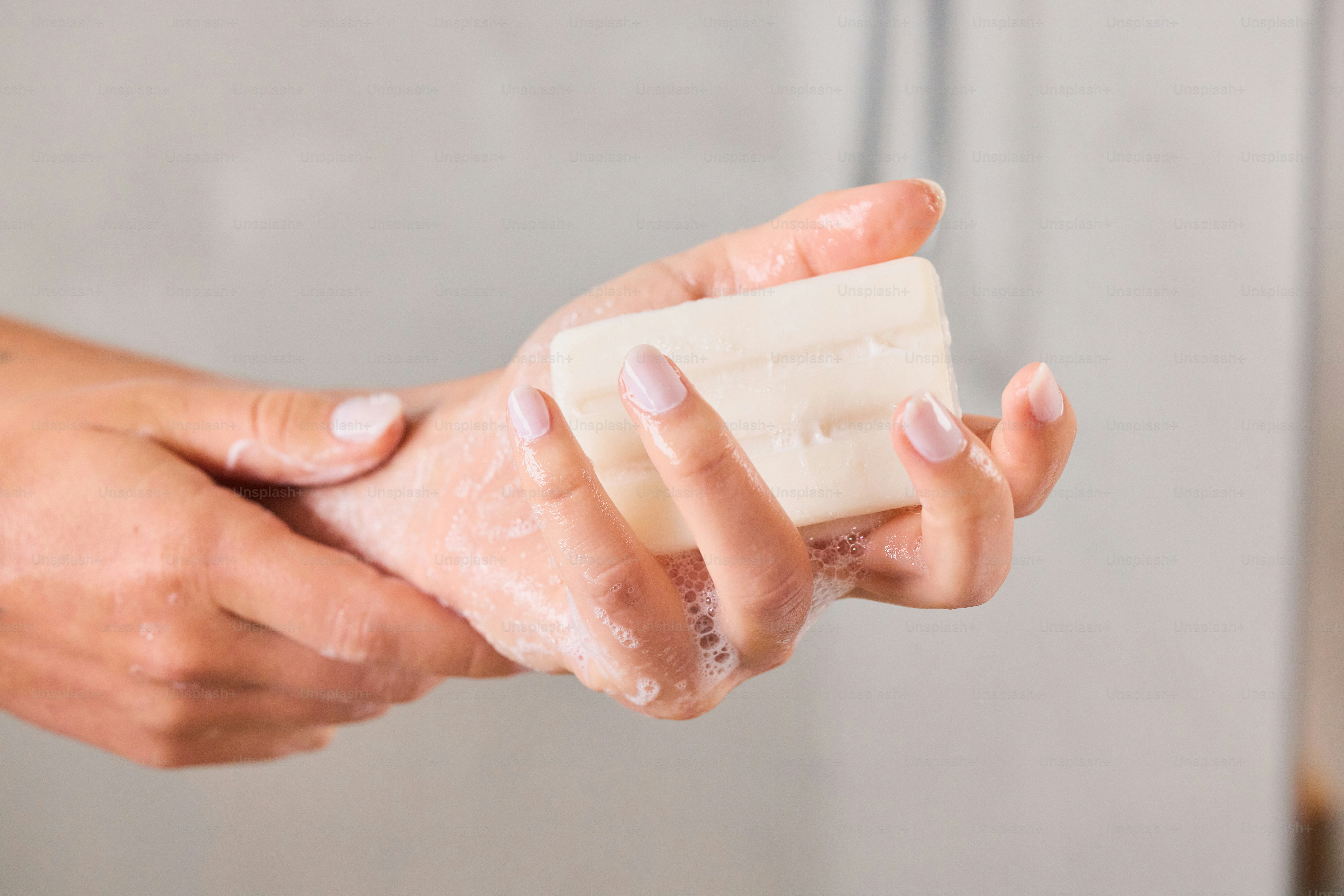 Hands washing with bar soap and suds