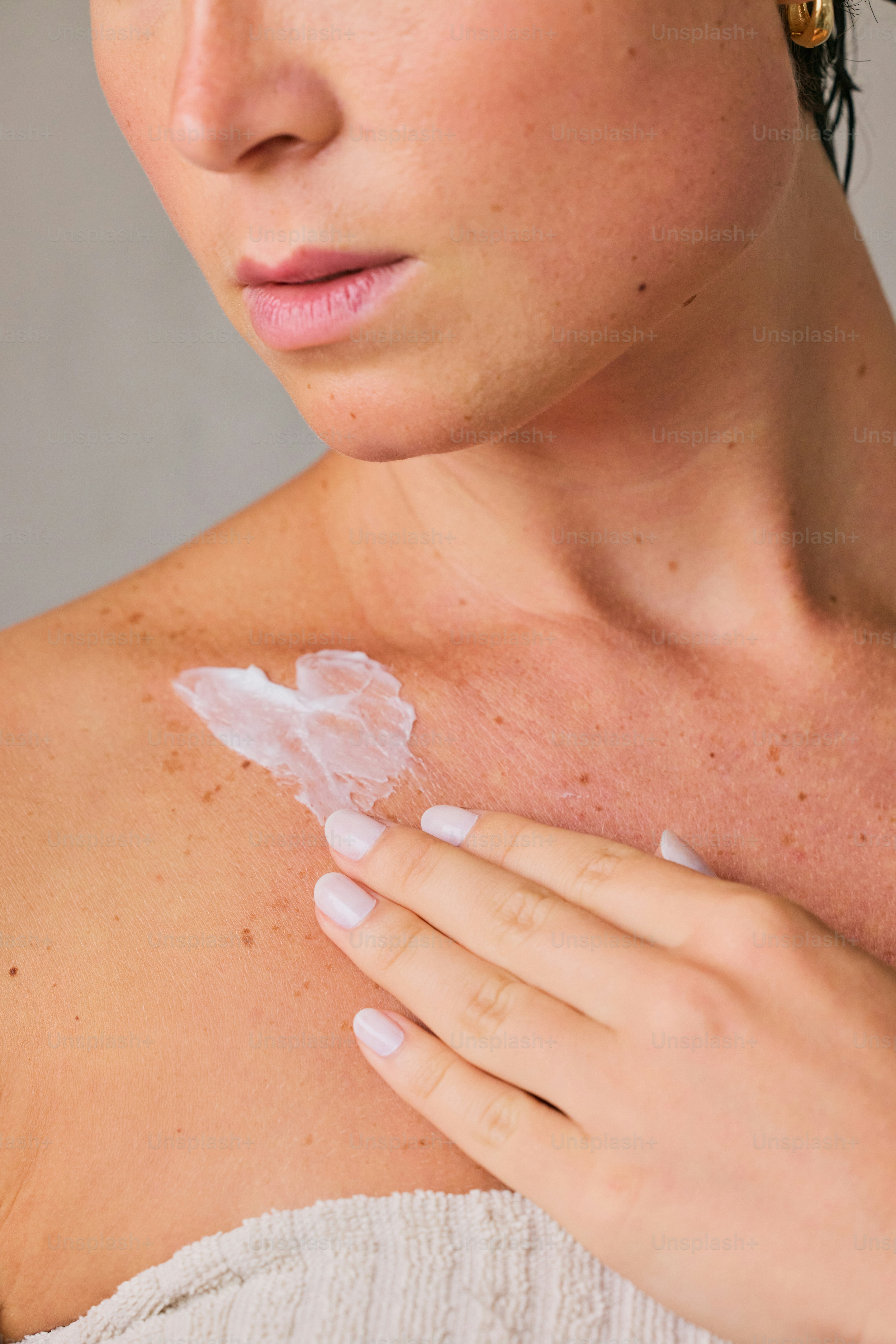 Woman applying cream to her chest